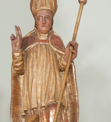 Zdjęcie nr 16: Ołtarz architektoniczny, z wydzieloną predellą, trójosiowy, dwukondygnacyjny ze zwieńczeniem. Predella węższa od nastawy, rozszerzająca się ku górze. Dolna kondygnacja artykułowana kolumnami o trzonach przedzielonych opaską w jednej trzeciej wysokości, zdobionych główkami aniołków, girlandami i dekoracją kandelabrową; kapitele kompozytowe; w osiach zewnętrznych kolumny nadwieszone na konsolach, w osiach wewnętrznych ustawione na postumentach. Kolumny wspierają belkowanie i gzyms występujące nad nimi. W polu środkowym prostokątna nisza zamknięta półkoliście, w niej obraz: Chrzest Chrystusa; w polach bocznych mniejsze nisze prostokątne zamknięte półkoliście, muszlowe, w nich rzeźby: Św. Piotr i Św. Paweł. Górna kondygnacja ujęta kolumnami o kręconych trzonach z dekoracją roślinną i kompozytowych kapitelach, wspierającymi belkowanie i profilowany gzyms. W polu środkowym nisza zamknięta półkoliście w niej obraz: Matka Boska z Dzieciątkiem. Po bokach obrazu rzeźby: Św. Anna (?) i Św. Marcin (?). Dolna i górna kondygnacje flankowane rzeźbionymi, ażurowymi uszakami z motywem herm aniołów. W osiach kolumn dolnej kondygnacji rzeźby: Św. Wojciech i Św. Stanisław. Zwieńczenie w kształcie półkolistego przyczółka wspartego na konsoli wchodzącej w pole górnej kondygnacji. W polu zwieńczenia płaskorzeźbione, półplastyczne przedstawienie Boga Ojca w popiersiu, flankowane wolutami z półpostaciami dwóch uskrzydlonych aniołów. Po bokach w zwieńczeniu, w osiach kolumn górnej kondygnacji, rzeźby uskrzydlonych aniołów.   W szczycie ołtarza na konsoli rzeźba: Św. Michał Archanioł. W przyłuczach nisz na obrazy, ponad niszami na rzeźby, w predelli, na konsolach i postumentach kolumn dolnej kondygnacji oraz na konsoli poniżej zwieńczenia uskrzydlone główki aniołków. Ponadto poniżej nisz, w tle kolumn oraz na belkowaniu płyciny ornamentalne z motywów roślinnych i motywy rautów. Struktura ołtarza, rzeźby i ornamenty złocone, karnacje i włosy polichromowane.  
