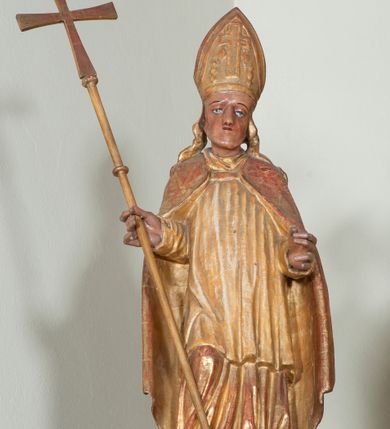 Zdjęcie nr 18: Ołtarz architektoniczny, z wydzieloną predellą, trójosiowy, dwukondygnacyjny ze zwieńczeniem. Predella węższa od nastawy, rozszerzająca się ku górze. Dolna kondygnacja artykułowana kolumnami o trzonach przedzielonych opaską w jednej trzeciej wysokości, zdobionych główkami aniołków, girlandami i dekoracją kandelabrową; kapitele kompozytowe; w osiach zewnętrznych kolumny nadwieszone na konsolach, w osiach wewnętrznych ustawione na postumentach. Kolumny wspierają belkowanie i gzyms występujące nad nimi. W polu środkowym prostokątna nisza zamknięta półkoliście, w niej obraz: Chrzest Chrystusa; w polach bocznych mniejsze nisze prostokątne zamknięte półkoliście, muszlowe, w nich rzeźby: Św. Piotr i Św. Paweł. Górna kondygnacja ujęta kolumnami o kręconych trzonach z dekoracją roślinną i kompozytowych kapitelach, wspierającymi belkowanie i profilowany gzyms. W polu środkowym nisza zamknięta półkoliście w niej obraz: Matka Boska z Dzieciątkiem. Po bokach obrazu rzeźby: Św. Anna (?) i Św. Marcin (?). Dolna i górna kondygnacje flankowane rzeźbionymi, ażurowymi uszakami z motywem herm aniołów. W osiach kolumn dolnej kondygnacji rzeźby: Św. Wojciech i Św. Stanisław. Zwieńczenie w kształcie półkolistego przyczółka wspartego na konsoli wchodzącej w pole górnej kondygnacji. W polu zwieńczenia płaskorzeźbione, półplastyczne przedstawienie Boga Ojca w popiersiu, flankowane wolutami z półpostaciami dwóch uskrzydlonych aniołów. Po bokach w zwieńczeniu, w osiach kolumn górnej kondygnacji, rzeźby uskrzydlonych aniołów.   W szczycie ołtarza na konsoli rzeźba: Św. Michał Archanioł. W przyłuczach nisz na obrazy, ponad niszami na rzeźby, w predelli, na konsolach i postumentach kolumn dolnej kondygnacji oraz na konsoli poniżej zwieńczenia uskrzydlone główki aniołków. Ponadto poniżej nisz, w tle kolumn oraz na belkowaniu płyciny ornamentalne z motywów roślinnych i motywy rautów. Struktura ołtarza, rzeźby i ornamenty złocone, karnacje i włosy polichromowane.  
