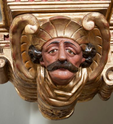Zdjęcie nr 33: Ołtarz architektoniczny, z wydzieloną predellą, trójosiowy, dwukondygnacyjny ze zwieńczeniem. Predella węższa od nastawy, rozszerzająca się ku górze. Dolna kondygnacja artykułowana kolumnami o trzonach przedzielonych opaską w jednej trzeciej wysokości, zdobionych główkami aniołków, girlandami i dekoracją kandelabrową; kapitele kompozytowe; w osiach zewnętrznych kolumny nadwieszone na konsolach, w osiach wewnętrznych ustawione na postumentach. Kolumny wspierają belkowanie i gzyms występujące nad nimi. W polu środkowym prostokątna nisza zamknięta półkoliście, w niej obraz: Chrzest Chrystusa; w polach bocznych mniejsze nisze prostokątne zamknięte półkoliście, muszlowe, w nich rzeźby: Św. Piotr i Św. Paweł. Górna kondygnacja ujęta kolumnami o kręconych trzonach z dekoracją roślinną i kompozytowych kapitelach, wspierającymi belkowanie i profilowany gzyms. W polu środkowym nisza zamknięta półkoliście w niej obraz: Matka Boska z Dzieciątkiem. Po bokach obrazu rzeźby: Św. Anna (?) i Św. Marcin (?). Dolna i górna kondygnacje flankowane rzeźbionymi, ażurowymi uszakami z motywem herm aniołów. W osiach kolumn dolnej kondygnacji rzeźby: Św. Wojciech i Św. Stanisław. Zwieńczenie w kształcie półkolistego przyczółka wspartego na konsoli wchodzącej w pole górnej kondygnacji. W polu zwieńczenia płaskorzeźbione, półplastyczne przedstawienie Boga Ojca w popiersiu, flankowane wolutami z półpostaciami dwóch uskrzydlonych aniołów. Po bokach w zwieńczeniu, w osiach kolumn górnej kondygnacji, rzeźby uskrzydlonych aniołów.   W szczycie ołtarza na konsoli rzeźba: Św. Michał Archanioł. W przyłuczach nisz na obrazy, ponad niszami na rzeźby, w predelli, na konsolach i postumentach kolumn dolnej kondygnacji oraz na konsoli poniżej zwieńczenia uskrzydlone główki aniołków. Ponadto poniżej nisz, w tle kolumn oraz na belkowaniu płyciny ornamentalne z motywów roślinnych i motywy rautów. Struktura ołtarza, rzeźby i ornamenty złocone, karnacje i włosy polichromowane.  
