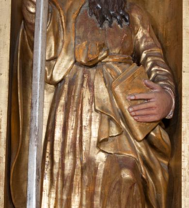 Zdjęcie nr 10: Ołtarz architektoniczny, z wydzieloną predellą, trójosiowy, dwukondygnacyjny ze zwieńczeniem. Predella węższa od nastawy, rozszerzająca się ku górze. Dolna kondygnacja artykułowana kolumnami o trzonach przedzielonych opaską w jednej trzeciej wysokości, zdobionych główkami aniołków, girlandami i dekoracją kandelabrową; kapitele kompozytowe; w osiach zewnętrznych kolumny nadwieszone na konsolach, w osiach wewnętrznych ustawione na postumentach. Kolumny wspierają belkowanie i gzyms występujące nad nimi. W polu środkowym prostokątna nisza zamknięta półkoliście, w niej obraz: Chrzest Chrystusa; w polach bocznych mniejsze nisze prostokątne zamknięte półkoliście, muszlowe, w nich rzeźby: Św. Piotr i Św. Paweł. Górna kondygnacja ujęta kolumnami o kręconych trzonach z dekoracją roślinną i kompozytowych kapitelach, wspierającymi belkowanie i profilowany gzyms. W polu środkowym nisza zamknięta półkoliście w niej obraz: Matka Boska z Dzieciątkiem. Po bokach obrazu rzeźby: Św. Anna (?) i Św. Marcin (?). Dolna i górna kondygnacje flankowane rzeźbionymi, ażurowymi uszakami z motywem herm aniołów. W osiach kolumn dolnej kondygnacji rzeźby: Św. Wojciech i Św. Stanisław. Zwieńczenie w kształcie półkolistego przyczółka wspartego na konsoli wchodzącej w pole górnej kondygnacji. W polu zwieńczenia płaskorzeźbione, półplastyczne przedstawienie Boga Ojca w popiersiu, flankowane wolutami z półpostaciami dwóch uskrzydlonych aniołów. Po bokach w zwieńczeniu, w osiach kolumn górnej kondygnacji, rzeźby uskrzydlonych aniołów.   W szczycie ołtarza na konsoli rzeźba: Św. Michał Archanioł. W przyłuczach nisz na obrazy, ponad niszami na rzeźby, w predelli, na konsolach i postumentach kolumn dolnej kondygnacji oraz na konsoli poniżej zwieńczenia uskrzydlone główki aniołków. Ponadto poniżej nisz, w tle kolumn oraz na belkowaniu płyciny ornamentalne z motywów roślinnych i motywy rautów. Struktura ołtarza, rzeźby i ornamenty złocone, karnacje i włosy polichromowane.  
