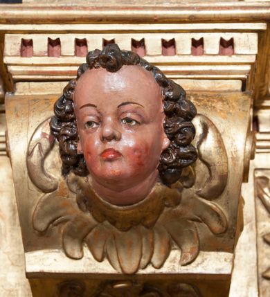 Zdjęcie nr 45: Ołtarz architektoniczny, z wydzieloną predellą, trójosiowy, dwukondygnacyjny ze zwieńczeniem. Predella węższa od nastawy, rozszerzająca się ku górze. Dolna kondygnacja artykułowana kolumnami o trzonach przedzielonych opaską w jednej trzeciej wysokości, zdobionych główkami aniołków, girlandami i dekoracją kandelabrową; kapitele kompozytowe; w osiach zewnętrznych kolumny nadwieszone na konsolach, w osiach wewnętrznych ustawione na postumentach. Kolumny wspierają belkowanie i gzyms występujące nad nimi. W polu środkowym prostokątna nisza zamknięta półkoliście, w niej obraz: Chrzest Chrystusa; w polach bocznych mniejsze nisze prostokątne zamknięte półkoliście, muszlowe, w nich rzeźby: Św. Piotr i Św. Paweł. Górna kondygnacja ujęta kolumnami o kręconych trzonach z dekoracją roślinną i kompozytowych kapitelach, wspierającymi belkowanie i profilowany gzyms. W polu środkowym nisza zamknięta półkoliście w niej obraz: Matka Boska z Dzieciątkiem. Po bokach obrazu rzeźby: Św. Anna (?) i Św. Marcin (?). Dolna i górna kondygnacje flankowane rzeźbionymi, ażurowymi uszakami z motywem herm aniołów. W osiach kolumn dolnej kondygnacji rzeźby: Św. Wojciech i Św. Stanisław. Zwieńczenie w kształcie półkolistego przyczółka wspartego na konsoli wchodzącej w pole górnej kondygnacji. W polu zwieńczenia płaskorzeźbione, półplastyczne przedstawienie Boga Ojca w popiersiu, flankowane wolutami z półpostaciami dwóch uskrzydlonych aniołów. Po bokach w zwieńczeniu, w osiach kolumn górnej kondygnacji, rzeźby uskrzydlonych aniołów.   W szczycie ołtarza na konsoli rzeźba: Św. Michał Archanioł. W przyłuczach nisz na obrazy, ponad niszami na rzeźby, w predelli, na konsolach i postumentach kolumn dolnej kondygnacji oraz na konsoli poniżej zwieńczenia uskrzydlone główki aniołków. Ponadto poniżej nisz, w tle kolumn oraz na belkowaniu płyciny ornamentalne z motywów roślinnych i motywy rautów. Struktura ołtarza, rzeźby i ornamenty złocone, karnacje i włosy polichromowane.  
