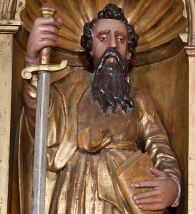 Zdjęcie nr 1: Rzeźba pełnoplastyczna, przyścienna, ścięta z tyłu. Figura zwrócona frontalnie do widza, święty lewą nogę opiera na rzeźbionym fragmencie skały; w prawej ręce unosi zwrócony ostrzem w dół duży miecz, lewą podtrzymuje opartą na biodrze księgę. Twarz pociągła, o głęboko osadzonych, półprzymkniętych oczach, dużym prostym nosie, okolona długą brodą opadającą na pierś. Włosy krótkie, falowane. Święty ubrany w tunikę z długimi rękawami, przepasaną w talii, u dołu obficie drapowaną w równoległe fałdy oraz płaszcz przerzucony przez prawe ramię i przewieszony przez pas na lewym boku. Figura delikatnie poruszona, o niewłaściwych proporcjach anatomicznych. Polichromia naturalistyczna w partiach ciała, szaty złocone, miecz srebrzony.