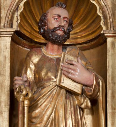 Zdjęcie nr 1: Rzeźba pełnoplastyczna, przyścienna, ścięta z tyłu. Figura zwrócona frontalnie do widza, z głową skierowaną w prawą stronę. Święty prawą nogę opiera na rzeźbionym fragmencie skały; w prawej, wyciągniętej przed siebie ręce trzyma klucze, lewą podtrzymuje przy piersi księgę. Twarz pociągła, o głęboko osadzonych, półprzymkniętych oczach, dużym prostym nosie, okolona brodą. Włosy krótkie, falowane w postaci pukli po bokach i na czubku głowy. Święty ubrany w tunikę z długimi rękawami, przepasaną w talii, u dołu obficie drapowaną w równoległe fałdy, oraz płaszcz przerzucony przez lewe ramię oraz przewieszony przez pas na prawym boku. Rzeźba, delikatnie poruszona, o zaburzonych proporcjach ciała. Polichromia naturalistyczna w partiach ciała, szaty złocone.