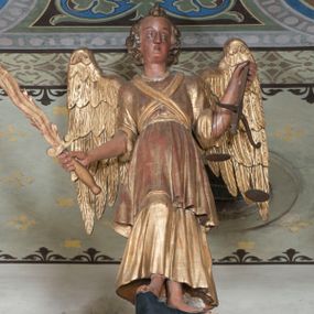 Zdjęcie nr 1: Rzeźba pełnoplastyczna, przyścienna, ścięta z tyłu. Archanioł, ukazany frontalnie, stoi w lekkim kontrapoście, prawą nogę opierając na rzeźbionym fragmencie skały. W prawej ręce unosi zwrócony ostrzem do góry płonący miecz, w lewej trzyma wagę. Twarz szczupła, o młodzieńczych rysach. Włosy krótkie, układające się gęstymi puklami, z czubem pośrodku. Ubrany w długą szatę spodnią, szatę wierzchnią sięgającą do kolan i przepasaną w talii, na piersiach skrzyżowana szarfa. Skrzydła rozłożone na boki. Polichromia naturalistyczna w partiach ciała, szaty i atrybuty złocone.