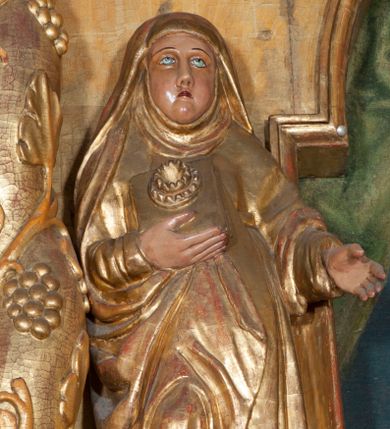 Zdjęcie nr 1: Rzeźba pełnoplastyczna, przyścienna, ścięta z tyłu. Święta ukazana frontalnie, w lekkim kontrapoście, z prawą nogą ugiętą w kolanie i wysuniętą stopą. Ręce ugięte w łokciach. Prawą dłonią przyciska przez połę płaszcza nierozpoznany przedmiot; lewą wyciąga przed siebie. Twarz okrągła, pełna, o rysach dojrzałej kobiety, oczy zwrócone ku górze. Ubrana w przewiązaną w pasie tunikę oraz płaszcz podwinięty pod prawą ręką i odsłaniający prawą nogę, na głowie długi welon z podwiką. Polichromia naturalistyczna w partiach ciała, szaty złocone.