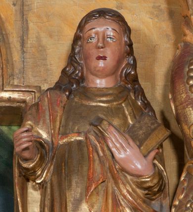 Zdjęcie nr 1: Rzeźba pełnoplastyczna, przyścienna, ścięta z tyłu. Święty, ukazany frontalnie, w lekkim kontrapoście, z lewą nogą ugiętą w kolanie i wysuniętą stopą. Lewą ręką przytrzymuje na piersi księgę, prawą wyciąga przed siebie. Twarz okrągła, pełna, o młodzieńczych rysach, oczy zwrócone ku górze. Włosy długie, falowane, opadają na ramiona i plecy. Ubrany w tunikę oraz płaszcz przerzucony przez prawe ramie i zawinięty na lewym boku. Przy lewej nodze niewielka półpostać mężczyzny w stożkowym nakryciu głowy. Polichromia naturalistyczna w partiach ciała, szaty złocone.