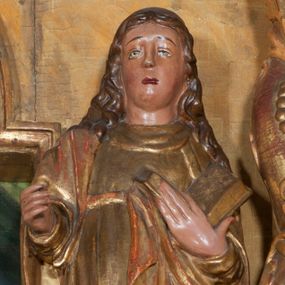 Zdjęcie nr 1: Rzeźba pełnoplastyczna, przyścienna, ścięta z tyłu. Święty, ukazany frontalnie, w lekkim kontrapoście, z lewą nogą ugiętą w kolanie i wysuniętą stopą. Lewą ręką przytrzymuje na piersi księgę, prawą wyciąga przed siebie. Twarz okrągła, pełna, o młodzieńczych rysach, oczy zwrócone ku górze. Włosy długie, falowane, opadają na ramiona i plecy. Ubrany w tunikę oraz płaszcz przerzucony przez prawe ramie i zawinięty na lewym boku. Przy lewej nodze niewielka półpostać mężczyzny w stożkowym nakryciu głowy. Polichromia naturalistyczna w partiach ciała, szaty złocone.