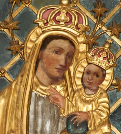 Zdjęcie nr 3: Obraz w formie stojącego prostokąta zamkniętego łukiem półkolistym nadwieszonym. Twarze postaci malowane są na płótnie, pozostałe elementy są płaskorzeźbione. W centrum kompozycji całopostaciowe przedstawienie Matki Boskiej z Dzieciątkiem stojącej na globie i sierpie księżyca. Maria ukazana jest frontalnie, z opuszczoną głową skierowaną w lewo, prawą, ugiętą rękę trzyma z przodu, lewą podtrzymuje Dzieciątko. Twarz ma owalną, o dużych, okrągłych oczach i nosie, pełnych ustach, okoloną brązowymi włosami. Ubrana jest w srebrzoną, długą suknię oraz długi, złocony płaszcz zarzucony na głowę i ramiona. Dzieciątko ukazane jest w pozycji siedzącej, zwrócone w trzech czwartych w prawo. Lewą ręką przytrzymuje na kolanie kulę, prawą unosi w geście błogosławieństwa. Twarz ma okrągłą, o dużych oczach, małym nosie i pełnych ustach, okoloną jasnobrązowymi, krótkimi włosami. Ubrane jest w luźną, złoconą tunikę. Na głowach obu postaci korony zamknięte, wokół nich nimby zamknięte i gwieździste. Maria i Dzieciątko ukazane na tle kratki wypełnionej taflami lustra. Obraz ujęty złoconą ramą. 

