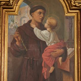 Zdjęcie nr 1: Obraz w formie stojącego prostokąta zamkniętego łukiem półkolistym nadwieszonym. W centrum kompozycji św. Antoni ukazany do kolan, zwrócony w trzech czwartych w lewo. W prawej, ugiętej i uniesionej ręce trzyma gałązkę lilii, lewą podtrzymuje Dzieciątko. Twarz ma szczupłą, o migdałowatych oczach skierowanych w górę, garbatym nosie i pełnych ustach, na głowie ma tonsurę. Ubrany jest w brązowy habit franciszkański, przepasany sznurem z zawieszonym różańcem. Dzieciątko w pozycji siedzącej, ukazane tyłem, zwrócone w trzech czwartych, lewą ręką ujmuję za szyję świętego. Twarz ma pełną, okoloną, jasnymi, krótkimi włosami. Ubrane jest w białą tunikę ze złoconą lamówką u szyi oraz czerwony płaszcz wokół bioder. Postacie ukazane we wnętrzu. W prawej części obrazu pulpit z otwartą księgą i krucyfiksem, w lewej części obrazu okno z widocznym w tle budynkiem. 
