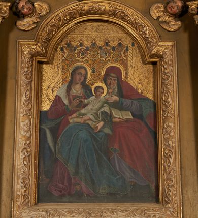 Zdjęcie nr 6: Nastawa ołtarzowa architektoniczna, jednoosiowa, jednokondygnacyjna ze zwieńczeniem. Ołtarz drewniany, prostopadłościenny, mensa drewniana. Antepedium w profilowanej ramie, z malowanym krzyżem, kotwicą i gorejącym sercem, w otoczeniu kwiatów. Predella na na niskim cokole, flankowana dwoma pilastrami, dźwigającymi gzyms wieńczący, wyłamany w partii pilastrów i tabernakulum po środku. Trzony pilastrów dekorowane ornamentem okuciowym z kaboszonami. W polach pomiędzy nimi malowane półpostacie aniołów, u spodu parapet z przedstawieniem arma Christi. Lewa postać z palmą, prawa ze włócznią i sakiewką. Ukazane na złoconym tle z tłoczonym ornamentem roślinnym. Drzwiczki tabernakulum w formie stojącego prostokąta z przedstawieniem kielicha z hostią z monogramen IHS, w glorii. Nastawa ujęta parą zdwojonych pilastrów zwróconych do wewnątrz, o kanelowanych trzonach i kapitelach kompozytowych dekorowanych rocaille'm. Podpory dźwigają fragmenty przerwanego belkowania i ćwierćkolistego, przerwanego przyczółka, na których siedzi para puttów. W polu środkowym płycina w formie stojącego prostokąta zamkniętego łukiem półkolistym nadwieszonym ujęta grubą ramą dekorowaną akantem z obrazem św. Anny Samotrzeć. W przyłuczach dwie uskrzydlone główki anielskie. Kondygnacja ujęta ażurowymi, akantowymi uszami. Zwieńczenie w formie stojącego prostokąta ujętego utworzonymi z rocaille'u i muszli spływami wolutowymi, zamknięte fragmentem gzymsu, na którym znajduje się szczyt utworzony z przeciwstawnie zwróconych wolut z anthemionem. W polu zwieńczenia obraz w formie stojącego prostokąta z przedstawieniem św. Józefa z Dzieciątkiem. Struktura ołtarza malowana na kolor jasnobrązowy, profile i ornamenty złocone.