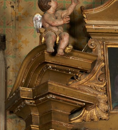 Zdjęcie nr 8: Nastawa ołtarzowa architektoniczna, jednoosiowa, jednokondygnacyjna ze zwieńczeniem. Ołtarz drewniany, prostopadłościenny, mensa drewniana. Antepedium w profilowanej ramie, z malowanym krzyżem, kotwicą i gorejącym sercem, w otoczeniu kwiatów. Predella na na niskim cokole, flankowana dwoma pilastrami, dźwigającymi gzyms wieńczący, wyłamany w partii pilastrów i tabernakulum po środku. Trzony pilastrów dekorowane ornamentem okuciowym z kaboszonami. W polach pomiędzy nimi malowane półpostacie aniołów, u spodu parapet z przedstawieniem arma Christi. Lewa postać z palmą, prawa ze włócznią i sakiewką. Ukazane na złoconym tle z tłoczonym ornamentem roślinnym. Drzwiczki tabernakulum w formie stojącego prostokąta z przedstawieniem kielicha z hostią z monogramen IHS, w glorii. Nastawa ujęta parą zdwojonych pilastrów zwróconych do wewnątrz, o kanelowanych trzonach i kapitelach kompozytowych dekorowanych rocaille'm. Podpory dźwigają fragmenty przerwanego belkowania i ćwierćkolistego, przerwanego przyczółka, na których siedzi para puttów. W polu środkowym płycina w formie stojącego prostokąta zamkniętego łukiem półkolistym nadwieszonym ujęta grubą ramą dekorowaną akantem z obrazem św. Anny Samotrzeć. W przyłuczach dwie uskrzydlone główki anielskie. Kondygnacja ujęta ażurowymi, akantowymi uszami. Zwieńczenie w formie stojącego prostokąta ujętego utworzonymi z rocaille'u i muszli spływami wolutowymi, zamknięte fragmentem gzymsu, na którym znajduje się szczyt utworzony z przeciwstawnie zwróconych wolut z anthemionem. W polu zwieńczenia obraz w formie stojącego prostokąta z przedstawieniem św. Józefa z Dzieciątkiem. Struktura ołtarza malowana na kolor jasnobrązowy, profile i ornamenty złocone.
