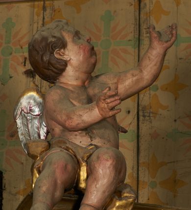 Zdjęcie nr 9: Nastawa ołtarzowa architektoniczna, jednoosiowa, jednokondygnacyjna ze zwieńczeniem. Ołtarz drewniany, prostopadłościenny, mensa drewniana. Antepedium w profilowanej ramie, z malowanym krzyżem, kotwicą i gorejącym sercem, w otoczeniu kwiatów. Predella na na niskim cokole, flankowana dwoma pilastrami, dźwigającymi gzyms wieńczący, wyłamany w partii pilastrów i tabernakulum po środku. Trzony pilastrów dekorowane ornamentem okuciowym z kaboszonami. W polach pomiędzy nimi malowane półpostacie aniołów, u spodu parapet z przedstawieniem arma Christi. Lewa postać z palmą, prawa ze włócznią i sakiewką. Ukazane na złoconym tle z tłoczonym ornamentem roślinnym. Drzwiczki tabernakulum w formie stojącego prostokąta z przedstawieniem kielicha z hostią z monogramen IHS, w glorii. Nastawa ujęta parą zdwojonych pilastrów zwróconych do wewnątrz, o kanelowanych trzonach i kapitelach kompozytowych dekorowanych rocaille'm. Podpory dźwigają fragmenty przerwanego belkowania i ćwierćkolistego, przerwanego przyczółka, na których siedzi para puttów. W polu środkowym płycina w formie stojącego prostokąta zamkniętego łukiem półkolistym nadwieszonym ujęta grubą ramą dekorowaną akantem z obrazem św. Anny Samotrzeć. W przyłuczach dwie uskrzydlone główki anielskie. Kondygnacja ujęta ażurowymi, akantowymi uszami. Zwieńczenie w formie stojącego prostokąta ujętego utworzonymi z rocaille'u i muszli spływami wolutowymi, zamknięte fragmentem gzymsu, na którym znajduje się szczyt utworzony z przeciwstawnie zwróconych wolut z anthemionem. W polu zwieńczenia obraz w formie stojącego prostokąta z przedstawieniem św. Józefa z Dzieciątkiem. Struktura ołtarza malowana na kolor jasnobrązowy, profile i ornamenty złocone.