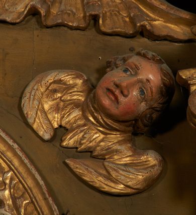 Zdjęcie nr 12: Nastawa ołtarzowa architektoniczna, jednoosiowa, jednokondygnacyjna ze zwieńczeniem. Ołtarz drewniany, prostopadłościenny, mensa drewniana. Antepedium w profilowanej ramie, z malowanym krzyżem, kotwicą i gorejącym sercem, w otoczeniu kwiatów. Predella na na niskim cokole, flankowana dwoma pilastrami, dźwigającymi gzyms wieńczący, wyłamany w partii pilastrów i tabernakulum po środku. Trzony pilastrów dekorowane ornamentem okuciowym z kaboszonami. W polach pomiędzy nimi malowane półpostacie aniołów, u spodu parapet z przedstawieniem arma Christi. Lewa postać z palmą, prawa ze włócznią i sakiewką. Ukazane na złoconym tle z tłoczonym ornamentem roślinnym. Drzwiczki tabernakulum w formie stojącego prostokąta z przedstawieniem kielicha z hostią z monogramen IHS, w glorii. Nastawa ujęta parą zdwojonych pilastrów zwróconych do wewnątrz, o kanelowanych trzonach i kapitelach kompozytowych dekorowanych rocaille'm. Podpory dźwigają fragmenty przerwanego belkowania i ćwierćkolistego, przerwanego przyczółka, na których siedzi para puttów. W polu środkowym płycina w formie stojącego prostokąta zamkniętego łukiem półkolistym nadwieszonym ujęta grubą ramą dekorowaną akantem z obrazem św. Anny Samotrzeć. W przyłuczach dwie uskrzydlone główki anielskie. Kondygnacja ujęta ażurowymi, akantowymi uszami. Zwieńczenie w formie stojącego prostokąta ujętego utworzonymi z rocaille'u i muszli spływami wolutowymi, zamknięte fragmentem gzymsu, na którym znajduje się szczyt utworzony z przeciwstawnie zwróconych wolut z anthemionem. W polu zwieńczenia obraz w formie stojącego prostokąta z przedstawieniem św. Józefa z Dzieciątkiem. Struktura ołtarza malowana na kolor jasnobrązowy, profile i ornamenty złocone.