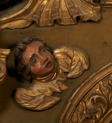 Zdjęcie nr 11: Nastawa ołtarzowa architektoniczna, jednoosiowa, jednokondygnacyjna ze zwieńczeniem. Ołtarz drewniany, prostopadłościenny, mensa drewniana. Antepedium w profilowanej ramie, z malowanym krzyżem, kotwicą i gorejącym sercem, w otoczeniu kwiatów. Predella na na niskim cokole, flankowana dwoma pilastrami, dźwigającymi gzyms wieńczący, wyłamany w partii pilastrów i tabernakulum po środku. Trzony pilastrów dekorowane ornamentem okuciowym z kaboszonami. W polach pomiędzy nimi malowane półpostacie aniołów, u spodu parapet z przedstawieniem arma Christi. Lewa postać z palmą, prawa ze włócznią i sakiewką. Ukazane na złoconym tle z tłoczonym ornamentem roślinnym. Drzwiczki tabernakulum w formie stojącego prostokąta z przedstawieniem kielicha z hostią z monogramen IHS, w glorii. Nastawa ujęta parą zdwojonych pilastrów zwróconych do wewnątrz, o kanelowanych trzonach i kapitelach kompozytowych dekorowanych rocaille'm. Podpory dźwigają fragmenty przerwanego belkowania i ćwierćkolistego, przerwanego przyczółka, na których siedzi para puttów. W polu środkowym płycina w formie stojącego prostokąta zamkniętego łukiem półkolistym nadwieszonym ujęta grubą ramą dekorowaną akantem z obrazem św. Anny Samotrzeć. W przyłuczach dwie uskrzydlone główki anielskie. Kondygnacja ujęta ażurowymi, akantowymi uszami. Zwieńczenie w formie stojącego prostokąta ujętego utworzonymi z rocaille'u i muszli spływami wolutowymi, zamknięte fragmentem gzymsu, na którym znajduje się szczyt utworzony z przeciwstawnie zwróconych wolut z anthemionem. W polu zwieńczenia obraz w formie stojącego prostokąta z przedstawieniem św. Józefa z Dzieciątkiem. Struktura ołtarza malowana na kolor jasnobrązowy, profile i ornamenty złocone.