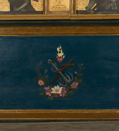 Zdjęcie nr 3: Nastawa ołtarzowa architektoniczna, jednoosiowa, jednokondygnacyjna ze zwieńczeniem. Ołtarz drewniany, prostopadłościenny, mensa drewniana. Antepedium w profilowanej ramie, z malowanym krzyżem, kotwicą i gorejącym sercem, w otoczeniu kwiatów. Predella na na niskim cokole, flankowana dwoma pilastrami, dźwigającymi gzyms wieńczący, wyłamany w partii pilastrów i tabernakulum po środku. Trzony pilastrów dekorowane ornamentem okuciowym z kaboszonami. W polach pomiędzy nimi malowane półpostacie aniołów, u spodu parapet z przedstawieniem arma Christi. Lewa postać z palmą, prawa ze włócznią i sakiewką. Ukazane na złoconym tle z tłoczonym ornamentem roślinnym. Drzwiczki tabernakulum w formie stojącego prostokąta z przedstawieniem kielicha z hostią z monogramen IHS, w glorii. Nastawa ujęta parą zdwojonych pilastrów zwróconych do wewnątrz, o kanelowanych trzonach i kapitelach kompozytowych dekorowanych rocaille'm. Podpory dźwigają fragmenty przerwanego belkowania i ćwierćkolistego, przerwanego przyczółka, na których siedzi para puttów. W polu środkowym płycina w formie stojącego prostokąta zamkniętego łukiem półkolistym nadwieszonym ujęta grubą ramą dekorowaną akantem z obrazem św. Anny Samotrzeć. W przyłuczach dwie uskrzydlone główki anielskie. Kondygnacja ujęta ażurowymi, akantowymi uszami. Zwieńczenie w formie stojącego prostokąta ujętego utworzonymi z rocaille'u i muszli spływami wolutowymi, zamknięte fragmentem gzymsu, na którym znajduje się szczyt utworzony z przeciwstawnie zwróconych wolut z anthemionem. W polu zwieńczenia obraz w formie stojącego prostokąta z przedstawieniem św. Józefa z Dzieciątkiem. Struktura ołtarza malowana na kolor jasnobrązowy, profile i ornamenty złocone.