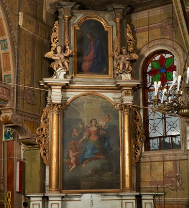 Zdjęcie nr 2: Nastawa architektoniczna, jednoosiowa, dwukondygnacyjna. Pierwsza kondygnacja ustawiona na cokole dekorowanym płycinami z wyodrębnioną parą prostopadłościanów oraz zewnętrznymi cokołami, flankowana parą kolumn o kapitelach kompozytowych dźwigających pełne belkowanie, wyłamane na ich osi, z architrawem i fryzem przerwanym polem obrazowym, oraz fragmenty przerwanego, falistego przyczółka, na którym znajduje się para puttów. Pole środkowe w całości wypełnione wnęką w formie stojącego prostokąta zamkniętego łukiem odcinkowym nadwieszonym z uskokiem, ujętą profilowaną ramą z obrazem Apoteozy św. Barbary. Kondygnacja flankowana uszami utworzonymi z ażurowego akantu. Druga kondygnacja ustawiona na niskim, profilowanym cokole, ujęta parą kolumn dźwigających fragmenty wyłamanego na ich osi belkowania. W polu wnęka w formie stojącego prostokąta zamkniętego łukiem półkolistym nadwieszonym, ujęta profilowaną ramą, z obrazem Modlitwy w Ogrojcu. Druga kondygnacja flankowana uszami utworzonymi z ażurowego akantu. Struktura polichromowana w kolorze jasnoszarym, profile, ornamentyka i kolumny złocone. 