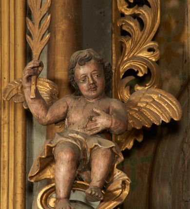 Zdjęcie nr 5: Nastawa architektoniczna, jednoosiowa, dwukondygnacyjna. Pierwsza kondygnacja ustawiona na cokole dekorowanym płycinami z wyodrębnioną parą prostopadłościanów oraz zewnętrznymi cokołami, flankowana parą kolumn o kapitelach kompozytowych dźwigających pełne belkowanie, wyłamane na ich osi, z architrawem i fryzem przerwanym polem obrazowym, oraz fragmenty przerwanego, falistego przyczółka, na którym znajduje się para puttów. Pole środkowe w całości wypełnione wnęką w formie stojącego prostokąta zamkniętego łukiem odcinkowym nadwieszonym z uskokiem, ujętą profilowaną ramą z obrazem Apoteozy św. Barbary. Kondygnacja flankowana uszami utworzonymi z ażurowego akantu. Druga kondygnacja ustawiona na niskim, profilowanym cokole, ujęta parą kolumn dźwigających fragmenty wyłamanego na ich osi belkowania. W polu wnęka w formie stojącego prostokąta zamkniętego łukiem półkolistym nadwieszonym, ujęta profilowaną ramą, z obrazem Modlitwy w Ogrojcu. Druga kondygnacja flankowana uszami utworzonymi z ażurowego akantu. Struktura polichromowana w kolorze jasnoszarym, profile, ornamentyka i kolumny złocone. 