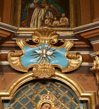 Zdjęcie nr 3: Nastawa architektoniczna, dwukondygnacyjna, jednoosiowa z bramkami. Ołtarz prostopadłościenny, drewniany, w jego polu malowane na drewnie przedstawienie Chrystusa w grobie; mensa drewniana. Pierwsza kondygnacja na niewysokim cokole, flankowana wewnętrzną parą pilastrów skierowaną pod kątem do wewnątrz oraz parą pilastrów i stojącą przed nimi parą kolumn zwróconymi pod kątem na zewnątrz. Podpory dźwigają pełne belkowanie, wyłamane na ich osi, w partii wewnętrznych pilastrów podtrzymywane przez konsole, nad kolumnami fragmenty przerwanego przyczółka zwróconego do wewnątrz, na którym znajduje się para puttów. W polu środkowym wnęka w formie stojącego prostokąta zamkniętego łukiem półkolistym nadwieszonym, ujęta profilowaną ramą z obrazem Matki Boskiej z Dzieciątkiem. W partii trzonów wewnętrznych pilastrów gabloty na wota. Nad obrazem, w partii belkowania kartusz utworzony z muszli z gołębicą Ducha Świętego w glorii promienistej. Kondygnacja flankowana uszami utworzonymi z suchego akantu. Druga kondygnacja w formie zbliżonej do kwadratu, ujęta parą filarów zwróconych pod kątem do wewnątrz, dźwigających belkowanie, wyłamanego na ich osi, niepełne nad polem. W polu środkowym obraz św. Mikołaja w formie zbliżonej do kwadratu, ujęty profilowaną ramą. Całość zakończona okiem Opatrzności na tle obłoków, w glorii promienistej. Bramki w formie arkad opartych na węgarach, zakończonych niskimi cokołami z figurami św. Dominika i św. Katarzyny Sieneńskiej. Struktura ołtarza malowana w kolorze brązowym, detale ciemnobrązowym, ornamentyka, profile i kolumny złocone.