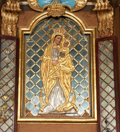 Zdjęcie nr 2: Nastawa architektoniczna, dwukondygnacyjna, jednoosiowa z bramkami. Ołtarz prostopadłościenny, drewniany, w jego polu malowane na drewnie przedstawienie Chrystusa w grobie; mensa drewniana. Pierwsza kondygnacja na niewysokim cokole, flankowana wewnętrzną parą pilastrów skierowaną pod kątem do wewnątrz oraz parą pilastrów i stojącą przed nimi parą kolumn zwróconymi pod kątem na zewnątrz. Podpory dźwigają pełne belkowanie, wyłamane na ich osi, w partii wewnętrznych pilastrów podtrzymywane przez konsole, nad kolumnami fragmenty przerwanego przyczółka zwróconego do wewnątrz, na którym znajduje się para puttów. W polu środkowym wnęka w formie stojącego prostokąta zamkniętego łukiem półkolistym nadwieszonym, ujęta profilowaną ramą z obrazem Matki Boskiej z Dzieciątkiem. W partii trzonów wewnętrznych pilastrów gabloty na wota. Nad obrazem, w partii belkowania kartusz utworzony z muszli z gołębicą Ducha Świętego w glorii promienistej. Kondygnacja flankowana uszami utworzonymi z suchego akantu. Druga kondygnacja w formie zbliżonej do kwadratu, ujęta parą filarów zwróconych pod kątem do wewnątrz, dźwigających belkowanie, wyłamanego na ich osi, niepełne nad polem. W polu środkowym obraz św. Mikołaja w formie zbliżonej do kwadratu, ujęty profilowaną ramą. Całość zakończona okiem Opatrzności na tle obłoków, w glorii promienistej. Bramki w formie arkad opartych na węgarach, zakończonych niskimi cokołami z figurami św. Dominika i św. Katarzyny Sieneńskiej. Struktura ołtarza malowana w kolorze brązowym, detale ciemnobrązowym, ornamentyka, profile i kolumny złocone.