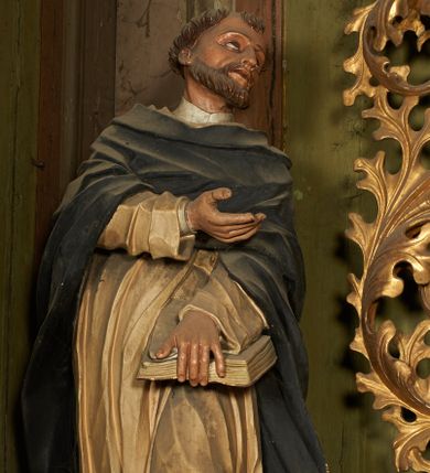 Zdjęcie nr 1: Figura drążona z tyłu, ustawiona na niewielkim postumencie. Święty ukazany frontalnie, pochylony w lewo, z uniesioną głową, w silnym kontrapoście. Lewą ręką przytrzymuje z przodu, na udzie księgę, prawą ugiętą, kieruje w lewo. Twarz ma szczupłą, o głęboko osadzonych, dużych oczach, skierowanych w górę, dużym nosie oraz wąskich, rozchylonych ustach. Twarz okolona jest krótką brodą oraz krótkimi włosami, na głowie tonsura. Święty ubrany w obficie fałdowany, biały habit dominikański oraz czarny płaszcz z kapturem. Polichromia ciała naturalistyczna.