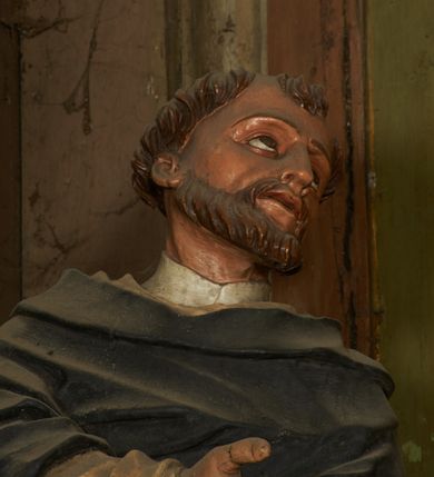 Zdjęcie nr 3: Figura drążona z tyłu, ustawiona na niewielkim postumencie. Święty ukazany frontalnie, pochylony w lewo, z uniesioną głową, w silnym kontrapoście. Lewą ręką przytrzymuje z przodu, na udzie księgę, prawą ugiętą, kieruje w lewo. Twarz ma szczupłą, o głęboko osadzonych, dużych oczach, skierowanych w górę, dużym nosie oraz wąskich, rozchylonych ustach. Twarz okolona jest krótką brodą oraz krótkimi włosami, na głowie tonsura. Święty ubrany w obficie fałdowany, biały habit dominikański oraz czarny płaszcz z kapturem. Polichromia ciała naturalistyczna.