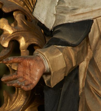 Zdjęcie nr 5: Figura drążona z tyłu, ustawiona na niskiej podstawie. Święta ukazana jest frontalnie, pochylona w prawo, w kontrapoście, z rozłożonymi na boki rękami. Twarz ma pociągłą, o dużych, migdałowatych oczach, dużym nosie i niewielkich, rozchylonych ustach. Ubrana jest w biały habit dominikański ze szkaplerzem, czarny płaszcz opadający na ramiona i plecy oraz biały welon, wokół twarzy ma podwikę, na głowie złoconą koronę cierniową. Polichromia ciała naturalistyczna. 
