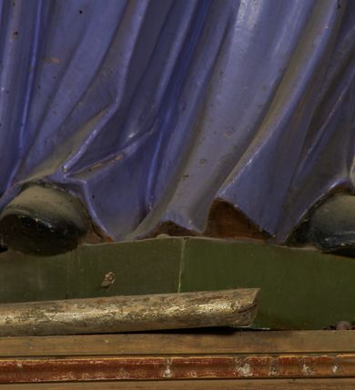 Zdjęcie nr 11: Figura drążona od tyłu, ustawiona na niewielkim prostopadłościennym postumencie. Święty ukazany jest frontalnie, w kontrapoście, o odchylonej sylwetce, z głową skierowaną w prawo. W lewej, ugiętej i odchylonej ręce trzyma laskę, prawą kładzie na piersi. Twarz ma szczupłą, podłużną o silnie zaznaczonych kościach policzkowych, dużych, migdałowatych oczach, lekko garbatym nosie i długich, wąskich, rozchylonych ustach, okoloną gęstą, brązową, kręconą brodą i kręconymi włosami. Święty ubrany jest w jasnofioletową sutannę, białą, złoconą przy brzegu komżę, czerwoną pelerynkę o różowej podszewce. Na piersi ma zawieszony pektorał. Przy lewej nodze biała, lamowana infuła ze złoconym krzyżem. Polichromia ciała naturalistyczna. 
