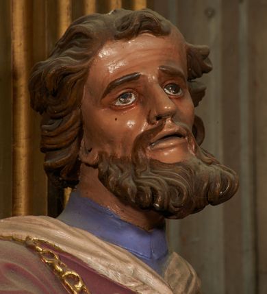 Zdjęcie nr 7: Figura drążona od tyłu, ustawiona na niewielkim prostopadłościennym postumencie. Święty ukazany jest frontalnie, w kontrapoście, o odchylonej sylwetce, z głową skierowaną w prawo. W lewej, ugiętej i odchylonej ręce trzyma laskę, prawą kładzie na piersi. Twarz ma szczupłą, podłużną o silnie zaznaczonych kościach policzkowych, dużych, migdałowatych oczach, lekko garbatym nosie i długich, wąskich, rozchylonych ustach, okoloną gęstą, brązową, kręconą brodą i kręconymi włosami. Święty ubrany jest w jasnofioletową sutannę, białą, złoconą przy brzegu komżę, czerwoną pelerynkę o różowej podszewce. Na piersi ma zawieszony pektorał. Przy lewej nodze biała, lamowana infuła ze złoconym krzyżem. Polichromia ciała naturalistyczna. 
