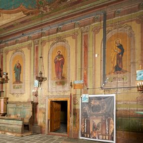Zdjęcie nr 1: Polichromia ścian kościoła odpowiada podziałom architektonicznym wnętrza wydzielonym przez pilastry, filary i kolumny (w prezbiterium iluzjonistyczne pilastry). Malowany jasnobrązowy cokół w jednej czwartej wysokości ścian zamknięty jest profilowanym gzymsem, w jego polu znajdują się jasnozielone malowane płyciny odpowiadające szerokości podziałów wnętrza. Trzony pilastrów bladoróżowe z malowanymi czerwonymi płycinami, w prezbiterium z kapitelami korynckimi, w nawie zakończone tryglifami. Podpory podtrzymują malowane belkowanie, z jasnoróżowym fryzem i wspornikami dekorowanymi anthemionami, dźwigającymi silnie wysunięty gzyms. W nawie belkowanie malowane jest w partii środkowej (bez zaskrzynień) podtrzymywanej przez filary i kolumny. W polach pomiędzy pilastrami malowane płyciny w formie prostokątów, o szerokości przęseł, ujęte ramą dekorowaną w narożach stylizowanym akantem z kampanulami. W prezbiterium w jasnożółtych płycinach znajdują się malowane nisze w formie stojącego prostokąta zamkniętego łukiem półkolistym, ujęte profilowaną ramą, dekorowaną u góry i u dołu ornamentem roślinnym, z przedstawieniami ewangelistów i ich symboli. Na ścianie północnej znajdują się św. Mateusz, św. Marek i św. Łukasz, a na ścianie południowej, pomiędzy okami św. Jan. W nawie jasnożółte płyciny ścian wypełnione są dekoracją geometryczną w formie niebieskich i żółtych równoramiennych krzyżyków. Otwory okienne, drzwiowe i arkada kaplicy ujęte są malowanymi, imitującymi profilowanie obramieniami, dekorowanymi ornamentem roślinnym. 
Strop prezbiterium i nawy w malowanej, kolorowej, profilowanej ramie, po wewnętrznej stronie z zielono-różowym pasem zdobionym ornamentem. Pośrodku, na tle malowanej jasnoróżowej płyciny, wydzielone pole o fantazyjnym kształcie, obwiedzione pomarańczową opaską z kartuszami na każdej stronie, ujętymi ornamentem roślinnym, wypełnionymi kratką i fantazyjną dekoracją. Jasnoniebieskie pole wypełnione jest malowanymi na złoto gwiazdami. W prezbiterium, w jego centrum kolejne pole o analogicznym kształcie ze sceną Wniebowzięcia Marii, a w nawie dwa pola ze scenami Chrystusa Zmartwychwstałego i Świętej Rodziny. W partii zaskrzynień nawy malowane płyciny w zielonych opaskach i jasnoróżowych polach wypełnione ornamentem geometrycznym. Jasnozielona balustrada chóru muzycznego dekorowana malowanymi płycinami w formie prostokątów, naprzemiennie stojących i leżących, flankujących środkowy medalion, wszystkie ujęte profilowaną ramą. Pola prostokątów stojących wypełnione rozetami na jasnoczerwonym tle. Pola prostokątów leżących wypełnione przedstawieniami instrumentów i ornamentu roślinnego ukazanych na żółtym tle. W środkowym medalionie przedstawienie Dawida grającego na harfie. 















