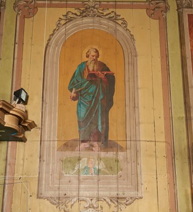 Zdjęcie nr 21: Polichromia ścian kościoła odpowiada podziałom architektonicznym wnętrza wydzielonym przez pilastry, filary i kolumny (w prezbiterium iluzjonistyczne pilastry). Malowany jasnobrązowy cokół w jednej czwartej wysokości ścian zamknięty jest profilowanym gzymsem, w jego polu znajdują się jasnozielone malowane płyciny odpowiadające szerokości podziałów wnętrza. Trzony pilastrów bladoróżowe z malowanymi czerwonymi płycinami, w prezbiterium z kapitelami korynckimi, w nawie zakończone tryglifami. Podpory podtrzymują malowane belkowanie, z jasnoróżowym fryzem i wspornikami dekorowanymi anthemionami, dźwigającymi silnie wysunięty gzyms. W nawie belkowanie malowane jest w partii środkowej (bez zaskrzynień) podtrzymywanej przez filary i kolumny. W polach pomiędzy pilastrami malowane płyciny w formie prostokątów, o szerokości przęseł, ujęte ramą dekorowaną w narożach stylizowanym akantem z kampanulami. W prezbiterium w jasnożółtych płycinach znajdują się malowane nisze w formie stojącego prostokąta zamkniętego łukiem półkolistym, ujęte profilowaną ramą, dekorowaną u góry i u dołu ornamentem roślinnym, z przedstawieniami ewangelistów i ich symboli. Na ścianie północnej znajdują się św. Mateusz, św. Marek i św. Łukasz, a na ścianie południowej, pomiędzy okami św. Jan. W nawie jasnożółte płyciny ścian wypełnione są dekoracją geometryczną w formie niebieskich i żółtych równoramiennych krzyżyków. Otwory okienne, drzwiowe i arkada kaplicy ujęte są malowanymi, imitującymi profilowanie obramieniami, dekorowanymi ornamentem roślinnym. 
Strop prezbiterium i nawy w malowanej, kolorowej, profilowanej ramie, po wewnętrznej stronie z zielono-różowym pasem zdobionym ornamentem. Pośrodku, na tle malowanej jasnoróżowej płyciny, wydzielone pole o fantazyjnym kształcie, obwiedzione pomarańczową opaską z kartuszami na każdej stronie, ujętymi ornamentem roślinnym, wypełnionymi kratką i fantazyjną dekoracją. Jasnoniebieskie pole wypełnione jest malowanymi na złoto gwiazdami. W prezbiterium, w jego centrum kolejne pole o analogicznym kształcie ze sceną Wniebowzięcia Marii, a w nawie dwa pola ze scenami Chrystusa Zmartwychwstałego i Świętej Rodziny. W partii zaskrzynień nawy malowane płyciny w zielonych opaskach i jasnoróżowych polach wypełnione ornamentem geometrycznym. Jasnozielona balustrada chóru muzycznego dekorowana malowanymi płycinami w formie prostokątów, naprzemiennie stojących i leżących, flankujących środkowy medalion, wszystkie ujęte profilowaną ramą. Pola prostokątów stojących wypełnione rozetami na jasnoczerwonym tle. Pola prostokątów leżących wypełnione przedstawieniami instrumentów i ornamentu roślinnego ukazanych na żółtym tle. W środkowym medalionie przedstawienie Dawida grającego na harfie. 















