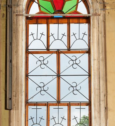 Zdjęcie nr 5: Polichromia ścian kościoła odpowiada podziałom architektonicznym wnętrza wydzielonym przez pilastry, filary i kolumny (w prezbiterium iluzjonistyczne pilastry). Malowany jasnobrązowy cokół w jednej czwartej wysokości ścian zamknięty jest profilowanym gzymsem, w jego polu znajdują się jasnozielone malowane płyciny odpowiadające szerokości podziałów wnętrza. Trzony pilastrów bladoróżowe z malowanymi czerwonymi płycinami, w prezbiterium z kapitelami korynckimi, w nawie zakończone tryglifami. Podpory podtrzymują malowane belkowanie, z jasnoróżowym fryzem i wspornikami dekorowanymi anthemionami, dźwigającymi silnie wysunięty gzyms. W nawie belkowanie malowane jest w partii środkowej (bez zaskrzynień) podtrzymywanej przez filary i kolumny. W polach pomiędzy pilastrami malowane płyciny w formie prostokątów, o szerokości przęseł, ujęte ramą dekorowaną w narożach stylizowanym akantem z kampanulami. W prezbiterium w jasnożółtych płycinach znajdują się malowane nisze w formie stojącego prostokąta zamkniętego łukiem półkolistym, ujęte profilowaną ramą, dekorowaną u góry i u dołu ornamentem roślinnym, z przedstawieniami ewangelistów i ich symboli. Na ścianie północnej znajdują się św. Mateusz, św. Marek i św. Łukasz, a na ścianie południowej, pomiędzy okami św. Jan. W nawie jasnożółte płyciny ścian wypełnione są dekoracją geometryczną w formie niebieskich i żółtych równoramiennych krzyżyków. Otwory okienne, drzwiowe i arkada kaplicy ujęte są malowanymi, imitującymi profilowanie obramieniami, dekorowanymi ornamentem roślinnym. 
Strop prezbiterium i nawy w malowanej, kolorowej, profilowanej ramie, po wewnętrznej stronie z zielono-różowym pasem zdobionym ornamentem. Pośrodku, na tle malowanej jasnoróżowej płyciny, wydzielone pole o fantazyjnym kształcie, obwiedzione pomarańczową opaską z kartuszami na każdej stronie, ujętymi ornamentem roślinnym, wypełnionymi kratką i fantazyjną dekoracją. Jasnoniebieskie pole wypełnione jest malowanymi na złoto gwiazdami. W prezbiterium, w jego centrum kolejne pole o analogicznym kształcie ze sceną Wniebowzięcia Marii, a w nawie dwa pola ze scenami Chrystusa Zmartwychwstałego i Świętej Rodziny. W partii zaskrzynień nawy malowane płyciny w zielonych opaskach i jasnoróżowych polach wypełnione ornamentem geometrycznym. Jasnozielona balustrada chóru muzycznego dekorowana malowanymi płycinami w formie prostokątów, naprzemiennie stojących i leżących, flankujących środkowy medalion, wszystkie ujęte profilowaną ramą. Pola prostokątów stojących wypełnione rozetami na jasnoczerwonym tle. Pola prostokątów leżących wypełnione przedstawieniami instrumentów i ornamentu roślinnego ukazanych na żółtym tle. W środkowym medalionie przedstawienie Dawida grającego na harfie. 















