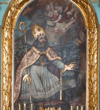 Zdjęcie nr 3: Nastawa ołtarzowa architektoniczna, jednokondygnacyjna, trójosiowa ze zwieńczeniem i z bramkami. Ołtarz prostopadłościenny, drewniany, mensa drewniana z kamiennym portatylem. Antependium w formie leżącego prostokąta ujętego złoconą, profilowaną ramą. W polu obraz malowany olejem na płótnie. W centrum kartusz w kształcie wydłużonego czwórliścia, dekorowany muszlą i wolutami z przedstawieniem pejzażu i widokiem na Golgotę. Po bokach kartusza bujne gałązki kwiatów. Tabernakulum w formie prostopadłościennej skrzynki o wypukłej ścianie frontowej, na profilowanym cokole, zamknięte profilowanym gzymsem, ujęte uszami utworzonymi z liści. Nad drzwiczkami, na gzymsie kartusz z niewielkim krucyfiksem. Powyżej tron wystawienia w formie profilowanej podstawy dekorowanej liśćmi. Na ściance frontowej tabernakulum profilowana rama w kształcie stojącego prostokąta zamkniętego łukiem nadwieszonym, w polu drzwiczki w formie stojącego prostokąta z przedstawieniem kielicha w glorii, powyżej drzwiczek winne grono. 

Nastawa ustawiona na zdwojonym cokole, dekorowanym wijącym się akantem. Osie kondygnacji wydzielone dwiema parami pilastrów oraz ustawionymi ukośnie kolumnami. Podpory dźwigają pełne belkowanie, przerwane nad polem środkowym i wyłamane nad osiami bocznymi, na których skraju ustawiony jest ukośnie przerwany, wolutowy przyczółek. Kolumny o kręconych trzonach, owinięte wicią liści akantu, kapitele korynckie; imposty ustawione pod kątem. W polu środkowym rama w kształcie stojącego prostokąta zamkniętego łukiem półkolistym z obrazem św. Kwiryna. W osiach bocznych płytkie płyciny, zwieńczone konchą z figurami św. Sebastiana po lewej stronie i św. Jana Nepomucena po prawej stronie, ustawionymi na wspornikach. Kondygnacja ujęta jest po bokach szerokimi uszami utworzonymi z liści akantu i karbowanej wstęgi. Fryz nad osiami bocznymi zdobiony kartuszami, we fryzie impostów z dwóch stron rozety; przyłucza osi bocznych dekorowane akantem.

W zwieńczeniu rzeźbiona półpostać Boga Ojca na obłoku z widocznym poniżej fragmentem globu ziemskiego i gołębicą Ducha Świętego; całość ukazana na tle promienistej glorii. Na belkowaniu, na osiach podpór wewnętrznych ustawione są rzeźby: św. Rocha  po lewej stronie i św. Wawrzyńca po prawej, a na zewnętrznych osiach retabulum rzeźby: Karola Boromeusza po lewej stronie i św. Stefana po prawej.

Nastawa ołtarzowa ujęta jest po bokach szerokimi bramkami w kształcie stojących prostokątów z drzwiczkami zamkniętymi półkoliście. Bramki ujęte są pilastrami o kanelowanych trzonach i fantazyjnych kapitelach, wspierających niepełne belkowanie oraz przerwany przyczółek. Nad bramkami ustawione są na cokołach rzeźby: św. Piotra po lewej stronie i św. Pawła po prawej. W polu drzwiczek owalne kartusze z herbem Görgey. W prawym kartuszu opisanym słowami: „BALTHAZAR GÖRGEI SENIOR”. Nad arkadami bramek są muszle, w przyłuczach akant, we fryzie rozety, a przerwany przyczółek dekorowany jest akantem. Struktura w całości polichromowana w odcieniu bladozielonym; ornamentyka, kolumny i profilowania złocone, detale srebrzone.