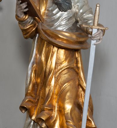 Zdjęcie nr 33: Nastawa ołtarzowa architektoniczna, jednokondygnacyjna, trójosiowa ze zwieńczeniem i z bramkami. Ołtarz prostopadłościenny, drewniany, mensa drewniana z kamiennym portatylem. Antependium w formie leżącego prostokąta ujętego złoconą, profilowaną ramą. W polu obraz malowany olejem na płótnie. W centrum kartusz w kształcie wydłużonego czwórliścia, dekorowany muszlą i wolutami z przedstawieniem pejzażu i widokiem na Golgotę. Po bokach kartusza bujne gałązki kwiatów. Tabernakulum w formie prostopadłościennej skrzynki o wypukłej ścianie frontowej, na profilowanym cokole, zamknięte profilowanym gzymsem, ujęte uszami utworzonymi z liści. Nad drzwiczkami, na gzymsie kartusz z niewielkim krucyfiksem. Powyżej tron wystawienia w formie profilowanej podstawy dekorowanej liśćmi. Na ściance frontowej tabernakulum profilowana rama w kształcie stojącego prostokąta zamkniętego łukiem nadwieszonym, w polu drzwiczki w formie stojącego prostokąta z przedstawieniem kielicha w glorii, powyżej drzwiczek winne grono. 

Nastawa ustawiona na zdwojonym cokole, dekorowanym wijącym się akantem. Osie kondygnacji wydzielone dwiema parami pilastrów oraz ustawionymi ukośnie kolumnami. Podpory dźwigają pełne belkowanie, przerwane nad polem środkowym i wyłamane nad osiami bocznymi, na których skraju ustawiony jest ukośnie przerwany, wolutowy przyczółek. Kolumny o kręconych trzonach, owinięte wicią liści akantu, kapitele korynckie; imposty ustawione pod kątem. W polu środkowym rama w kształcie stojącego prostokąta zamkniętego łukiem półkolistym z obrazem św. Kwiryna. W osiach bocznych płytkie płyciny, zwieńczone konchą z figurami św. Sebastiana po lewej stronie i św. Jana Nepomucena po prawej stronie, ustawionymi na wspornikach. Kondygnacja ujęta jest po bokach szerokimi uszami utworzonymi z liści akantu i karbowanej wstęgi. Fryz nad osiami bocznymi zdobiony kartuszami, we fryzie impostów z dwóch stron rozety; przyłucza osi bocznych dekorowane akantem.

W zwieńczeniu rzeźbiona półpostać Boga Ojca na obłoku z widocznym poniżej fragmentem globu ziemskiego i gołębicą Ducha Świętego; całość ukazana na tle promienistej glorii. Na belkowaniu, na osiach podpór wewnętrznych ustawione są rzeźby: św. Rocha  po lewej stronie i św. Wawrzyńca po prawej, a na zewnętrznych osiach retabulum rzeźby: Karola Boromeusza po lewej stronie i św. Stefana po prawej.

Nastawa ołtarzowa ujęta jest po bokach szerokimi bramkami w kształcie stojących prostokątów z drzwiczkami zamkniętymi półkoliście. Bramki ujęte są pilastrami o kanelowanych trzonach i fantazyjnych kapitelach, wspierających niepełne belkowanie oraz przerwany przyczółek. Nad bramkami ustawione są na cokołach rzeźby: św. Piotra po lewej stronie i św. Pawła po prawej. W polu drzwiczek owalne kartusze z herbem Görgey. W prawym kartuszu opisanym słowami: „BALTHAZAR GÖRGEI SENIOR”. Nad arkadami bramek są muszle, w przyłuczach akant, we fryzie rozety, a przerwany przyczółek dekorowany jest akantem. Struktura w całości polichromowana w odcieniu bladozielonym; ornamentyka, kolumny i profilowania złocone, detale srebrzone.