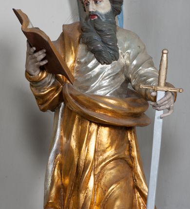 Zdjęcie nr 34: Nastawa ołtarzowa architektoniczna, jednokondygnacyjna, trójosiowa ze zwieńczeniem i z bramkami. Ołtarz prostopadłościenny, drewniany, mensa drewniana z kamiennym portatylem. Antependium w formie leżącego prostokąta ujętego złoconą, profilowaną ramą. W polu obraz malowany olejem na płótnie. W centrum kartusz w kształcie wydłużonego czwórliścia, dekorowany muszlą i wolutami z przedstawieniem pejzażu i widokiem na Golgotę. Po bokach kartusza bujne gałązki kwiatów. Tabernakulum w formie prostopadłościennej skrzynki o wypukłej ścianie frontowej, na profilowanym cokole, zamknięte profilowanym gzymsem, ujęte uszami utworzonymi z liści. Nad drzwiczkami, na gzymsie kartusz z niewielkim krucyfiksem. Powyżej tron wystawienia w formie profilowanej podstawy dekorowanej liśćmi. Na ściance frontowej tabernakulum profilowana rama w kształcie stojącego prostokąta zamkniętego łukiem nadwieszonym, w polu drzwiczki w formie stojącego prostokąta z przedstawieniem kielicha w glorii, powyżej drzwiczek winne grono. 

Nastawa ustawiona na zdwojonym cokole, dekorowanym wijącym się akantem. Osie kondygnacji wydzielone dwiema parami pilastrów oraz ustawionymi ukośnie kolumnami. Podpory dźwigają pełne belkowanie, przerwane nad polem środkowym i wyłamane nad osiami bocznymi, na których skraju ustawiony jest ukośnie przerwany, wolutowy przyczółek. Kolumny o kręconych trzonach, owinięte wicią liści akantu, kapitele korynckie; imposty ustawione pod kątem. W polu środkowym rama w kształcie stojącego prostokąta zamkniętego łukiem półkolistym z obrazem św. Kwiryna. W osiach bocznych płytkie płyciny, zwieńczone konchą z figurami św. Sebastiana po lewej stronie i św. Jana Nepomucena po prawej stronie, ustawionymi na wspornikach. Kondygnacja ujęta jest po bokach szerokimi uszami utworzonymi z liści akantu i karbowanej wstęgi. Fryz nad osiami bocznymi zdobiony kartuszami, we fryzie impostów z dwóch stron rozety; przyłucza osi bocznych dekorowane akantem.

W zwieńczeniu rzeźbiona półpostać Boga Ojca na obłoku z widocznym poniżej fragmentem globu ziemskiego i gołębicą Ducha Świętego; całość ukazana na tle promienistej glorii. Na belkowaniu, na osiach podpór wewnętrznych ustawione są rzeźby: św. Rocha  po lewej stronie i św. Wawrzyńca po prawej, a na zewnętrznych osiach retabulum rzeźby: Karola Boromeusza po lewej stronie i św. Stefana po prawej.

Nastawa ołtarzowa ujęta jest po bokach szerokimi bramkami w kształcie stojących prostokątów z drzwiczkami zamkniętymi półkoliście. Bramki ujęte są pilastrami o kanelowanych trzonach i fantazyjnych kapitelach, wspierających niepełne belkowanie oraz przerwany przyczółek. Nad bramkami ustawione są na cokołach rzeźby: św. Piotra po lewej stronie i św. Pawła po prawej. W polu drzwiczek owalne kartusze z herbem Görgey. W prawym kartuszu opisanym słowami: „BALTHAZAR GÖRGEI SENIOR”. Nad arkadami bramek są muszle, w przyłuczach akant, we fryzie rozety, a przerwany przyczółek dekorowany jest akantem. Struktura w całości polichromowana w odcieniu bladozielonym; ornamentyka, kolumny i profilowania złocone, detale srebrzone.