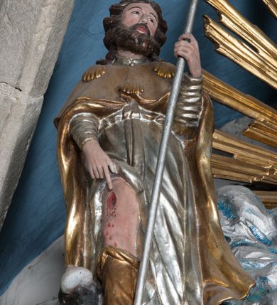 Zdjęcie nr 37: Nastawa ołtarzowa architektoniczna, jednokondygnacyjna, trójosiowa ze zwieńczeniem i z bramkami. Ołtarz prostopadłościenny, drewniany, mensa drewniana z kamiennym portatylem. Antependium w formie leżącego prostokąta ujętego złoconą, profilowaną ramą. W polu obraz malowany olejem na płótnie. W centrum kartusz w kształcie wydłużonego czwórliścia, dekorowany muszlą i wolutami z przedstawieniem pejzażu i widokiem na Golgotę. Po bokach kartusza bujne gałązki kwiatów. Tabernakulum w formie prostopadłościennej skrzynki o wypukłej ścianie frontowej, na profilowanym cokole, zamknięte profilowanym gzymsem, ujęte uszami utworzonymi z liści. Nad drzwiczkami, na gzymsie kartusz z niewielkim krucyfiksem. Powyżej tron wystawienia w formie profilowanej podstawy dekorowanej liśćmi. Na ściance frontowej tabernakulum profilowana rama w kształcie stojącego prostokąta zamkniętego łukiem nadwieszonym, w polu drzwiczki w formie stojącego prostokąta z przedstawieniem kielicha w glorii, powyżej drzwiczek winne grono. 

Nastawa ustawiona na zdwojonym cokole, dekorowanym wijącym się akantem. Osie kondygnacji wydzielone dwiema parami pilastrów oraz ustawionymi ukośnie kolumnami. Podpory dźwigają pełne belkowanie, przerwane nad polem środkowym i wyłamane nad osiami bocznymi, na których skraju ustawiony jest ukośnie przerwany, wolutowy przyczółek. Kolumny o kręconych trzonach, owinięte wicią liści akantu, kapitele korynckie; imposty ustawione pod kątem. W polu środkowym rama w kształcie stojącego prostokąta zamkniętego łukiem półkolistym z obrazem św. Kwiryna. W osiach bocznych płytkie płyciny, zwieńczone konchą z figurami św. Sebastiana po lewej stronie i św. Jana Nepomucena po prawej stronie, ustawionymi na wspornikach. Kondygnacja ujęta jest po bokach szerokimi uszami utworzonymi z liści akantu i karbowanej wstęgi. Fryz nad osiami bocznymi zdobiony kartuszami, we fryzie impostów z dwóch stron rozety; przyłucza osi bocznych dekorowane akantem.

W zwieńczeniu rzeźbiona półpostać Boga Ojca na obłoku z widocznym poniżej fragmentem globu ziemskiego i gołębicą Ducha Świętego; całość ukazana na tle promienistej glorii. Na belkowaniu, na osiach podpór wewnętrznych ustawione są rzeźby: św. Rocha  po lewej stronie i św. Wawrzyńca po prawej, a na zewnętrznych osiach retabulum rzeźby: Karola Boromeusza po lewej stronie i św. Stefana po prawej.

Nastawa ołtarzowa ujęta jest po bokach szerokimi bramkami w kształcie stojących prostokątów z drzwiczkami zamkniętymi półkoliście. Bramki ujęte są pilastrami o kanelowanych trzonach i fantazyjnych kapitelach, wspierających niepełne belkowanie oraz przerwany przyczółek. Nad bramkami ustawione są na cokołach rzeźby: św. Piotra po lewej stronie i św. Pawła po prawej. W polu drzwiczek owalne kartusze z herbem Görgey. W prawym kartuszu opisanym słowami: „BALTHAZAR GÖRGEI SENIOR”. Nad arkadami bramek są muszle, w przyłuczach akant, we fryzie rozety, a przerwany przyczółek dekorowany jest akantem. Struktura w całości polichromowana w odcieniu bladozielonym; ornamentyka, kolumny i profilowania złocone, detale srebrzone.