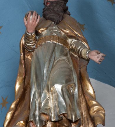 Zdjęcie nr 45: Nastawa ołtarzowa architektoniczna, jednokondygnacyjna, trójosiowa ze zwieńczeniem i z bramkami. Ołtarz prostopadłościenny, drewniany, mensa drewniana z kamiennym portatylem. Antependium w formie leżącego prostokąta ujętego złoconą, profilowaną ramą. W polu obraz malowany olejem na płótnie. W centrum kartusz w kształcie wydłużonego czwórliścia, dekorowany muszlą i wolutami z przedstawieniem pejzażu i widokiem na Golgotę. Po bokach kartusza bujne gałązki kwiatów. Tabernakulum w formie prostopadłościennej skrzynki o wypukłej ścianie frontowej, na profilowanym cokole, zamknięte profilowanym gzymsem, ujęte uszami utworzonymi z liści. Nad drzwiczkami, na gzymsie kartusz z niewielkim krucyfiksem. Powyżej tron wystawienia w formie profilowanej podstawy dekorowanej liśćmi. Na ściance frontowej tabernakulum profilowana rama w kształcie stojącego prostokąta zamkniętego łukiem nadwieszonym, w polu drzwiczki w formie stojącego prostokąta z przedstawieniem kielicha w glorii, powyżej drzwiczek winne grono. 

Nastawa ustawiona na zdwojonym cokole, dekorowanym wijącym się akantem. Osie kondygnacji wydzielone dwiema parami pilastrów oraz ustawionymi ukośnie kolumnami. Podpory dźwigają pełne belkowanie, przerwane nad polem środkowym i wyłamane nad osiami bocznymi, na których skraju ustawiony jest ukośnie przerwany, wolutowy przyczółek. Kolumny o kręconych trzonach, owinięte wicią liści akantu, kapitele korynckie; imposty ustawione pod kątem. W polu środkowym rama w kształcie stojącego prostokąta zamkniętego łukiem półkolistym z obrazem św. Kwiryna. W osiach bocznych płytkie płyciny, zwieńczone konchą z figurami św. Sebastiana po lewej stronie i św. Jana Nepomucena po prawej stronie, ustawionymi na wspornikach. Kondygnacja ujęta jest po bokach szerokimi uszami utworzonymi z liści akantu i karbowanej wstęgi. Fryz nad osiami bocznymi zdobiony kartuszami, we fryzie impostów z dwóch stron rozety; przyłucza osi bocznych dekorowane akantem.

W zwieńczeniu rzeźbiona półpostać Boga Ojca na obłoku z widocznym poniżej fragmentem globu ziemskiego i gołębicą Ducha Świętego; całość ukazana na tle promienistej glorii. Na belkowaniu, na osiach podpór wewnętrznych ustawione są rzeźby: św. Rocha  po lewej stronie i św. Wawrzyńca po prawej, a na zewnętrznych osiach retabulum rzeźby: Karola Boromeusza po lewej stronie i św. Stefana po prawej.

Nastawa ołtarzowa ujęta jest po bokach szerokimi bramkami w kształcie stojących prostokątów z drzwiczkami zamkniętymi półkoliście. Bramki ujęte są pilastrami o kanelowanych trzonach i fantazyjnych kapitelach, wspierających niepełne belkowanie oraz przerwany przyczółek. Nad bramkami ustawione są na cokołach rzeźby: św. Piotra po lewej stronie i św. Pawła po prawej. W polu drzwiczek owalne kartusze z herbem Görgey. W prawym kartuszu opisanym słowami: „BALTHAZAR GÖRGEI SENIOR”. Nad arkadami bramek są muszle, w przyłuczach akant, we fryzie rozety, a przerwany przyczółek dekorowany jest akantem. Struktura w całości polichromowana w odcieniu bladozielonym; ornamentyka, kolumny i profilowania złocone, detale srebrzone.