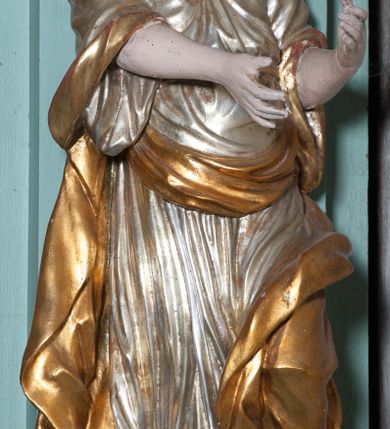 Zdjęcie nr 8: Ołtarz architektoniczny, dwukondygnacyjny, jednoosiowy. Ołtarz drewniany prostopadłościenny z drewnianą mensą i kamiennym portatylem. Dwukondygnacyjne retabulum ustawione na podwójnym i zdwojonym cokole, ujęte parą zdwojonych pilastrów wspierających wyłamujące się belkowanie. W polu głównym umieszczony jest obraz św. Mikołaja w płytkiej wnęce w kształcie stojącego prostokąta. Nad obrazem, w partii fryzu dwie uskrzydlone główki anielskie. Po bokach, na osi podpór, na wysokich cokołach ustawione są rzeźby: po lewej stronie św. Barbary, a po prawej według przekazów w literaturze św. Apolonii. Ponad nimi podwieszone ukośnie fragmenty fryzu ozdobione rozetami na ściankach bocznych, a od spodu szerokimi, zawiniętymi liśćmi akantu. Druga kondygnacja ustawiona na niskim cokole, ujęta parą zdwojonych pilastrów podtrzymujących przerwane belkowanie oraz wolutowy, odwrócony przyczółek, na którego szczycie usadzona jest para aniołków. W polu środkowym w ramie o kształcie stojącego prostokąta i ściętych narożach obraz św. Antoniego Padewskiego. Na osi podpór, na niskich cokołach ozdobionych rozetami ustawione są figury świętych królewiczów, zapewne. Ponad nimi podwieszone fragmenty fryzu, zdobione rozetami oraz z podwieszonymi szyszkami. Na szczycie retabulum niski cokolik, flankowany wolutami, zdobiony na przodzie rozetą z zatkniętym u góry krzyżem zakonu Bożogrobowców. Kondygnacje ujęte z lewej strony uszami: w dolnej suchym akantem, a w górnej akantem przeplecionym wstęgą, zdobioną cekinami. Kolorystyka struktury w kolorze jasnej zieleni, ornamentyka i detal architektoniczny złocone oraz srebrzone.
Napis na portatylu: „1963 d. 26 Jan. / celmus Ac erdemus Julianus / Groblicki, eppus tit philald / phiensis in arabia Auxil. Craco / ven, altare hoc portatile con / secravit et Reliquias Eses. Nn. /  brittcia rp. et florii in eo / inclusit” oraz podpisy piórem niebieskim oraz fragment pieczęci krakowskiej Bazyliki metropolitalnej.