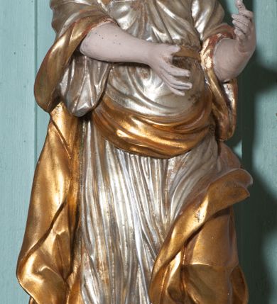 Zdjęcie nr 9: Ołtarz architektoniczny, dwukondygnacyjny, jednoosiowy. Ołtarz drewniany prostopadłościenny z drewnianą mensą i kamiennym portatylem. Dwukondygnacyjne retabulum ustawione na podwójnym i zdwojonym cokole, ujęte parą zdwojonych pilastrów wspierających wyłamujące się belkowanie. W polu głównym umieszczony jest obraz św. Mikołaja w płytkiej wnęce w kształcie stojącego prostokąta. Nad obrazem, w partii fryzu dwie uskrzydlone główki anielskie. Po bokach, na osi podpór, na wysokich cokołach ustawione są rzeźby: po lewej stronie św. Barbary, a po prawej według przekazów w literaturze św. Apolonii. Ponad nimi podwieszone ukośnie fragmenty fryzu ozdobione rozetami na ściankach bocznych, a od spodu szerokimi, zawiniętymi liśćmi akantu. Druga kondygnacja ustawiona na niskim cokole, ujęta parą zdwojonych pilastrów podtrzymujących przerwane belkowanie oraz wolutowy, odwrócony przyczółek, na którego szczycie usadzona jest para aniołków. W polu środkowym w ramie o kształcie stojącego prostokąta i ściętych narożach obraz św. Antoniego Padewskiego. Na osi podpór, na niskich cokołach ozdobionych rozetami ustawione są figury świętych królewiczów, zapewne. Ponad nimi podwieszone fragmenty fryzu, zdobione rozetami oraz z podwieszonymi szyszkami. Na szczycie retabulum niski cokolik, flankowany wolutami, zdobiony na przodzie rozetą z zatkniętym u góry krzyżem zakonu Bożogrobowców. Kondygnacje ujęte z lewej strony uszami: w dolnej suchym akantem, a w górnej akantem przeplecionym wstęgą, zdobioną cekinami. Kolorystyka struktury w kolorze jasnej zieleni, ornamentyka i detal architektoniczny złocone oraz srebrzone.
Napis na portatylu: „1963 d. 26 Jan. / celmus Ac erdemus Julianus / Groblicki, eppus tit philald / phiensis in arabia Auxil. Craco / ven, altare hoc portatile con / secravit et Reliquias Eses. Nn. /  brittcia rp. et florii in eo / inclusit” oraz podpisy piórem niebieskim oraz fragment pieczęci krakowskiej Bazyliki metropolitalnej.