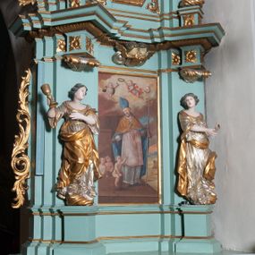 Zdjęcie nr 1: Ołtarz architektoniczny, dwukondygnacyjny, jednoosiowy. Ołtarz drewniany prostopadłościenny z drewnianą mensą i kamiennym portatylem. Dwukondygnacyjne retabulum ustawione na podwójnym i zdwojonym cokole, ujęte parą zdwojonych pilastrów wspierających wyłamujące się belkowanie. W polu głównym umieszczony jest obraz św. Mikołaja w płytkiej wnęce w kształcie stojącego prostokąta. Nad obrazem, w partii fryzu dwie uskrzydlone główki anielskie. Po bokach, na osi podpór, na wysokich cokołach ustawione są rzeźby: po lewej stronie św. Barbary, a po prawej według przekazów w literaturze św. Apolonii. Ponad nimi podwieszone ukośnie fragmenty fryzu ozdobione rozetami na ściankach bocznych, a od spodu szerokimi, zawiniętymi liśćmi akantu. Druga kondygnacja ustawiona na niskim cokole, ujęta parą zdwojonych pilastrów podtrzymujących przerwane belkowanie oraz wolutowy, odwrócony przyczółek, na którego szczycie usadzona jest para aniołków. W polu środkowym w ramie o kształcie stojącego prostokąta i ściętych narożach obraz św. Antoniego Padewskiego. Na osi podpór, na niskich cokołach ozdobionych rozetami ustawione są figury świętych królewiczów, zapewne. Ponad nimi podwieszone fragmenty fryzu, zdobione rozetami oraz z podwieszonymi szyszkami. Na szczycie retabulum niski cokolik, flankowany wolutami, zdobiony na przodzie rozetą z zatkniętym u góry krzyżem zakonu Bożogrobowców. Kondygnacje ujęte z lewej strony uszami: w dolnej suchym akantem, a w górnej akantem przeplecionym wstęgą, zdobioną cekinami. Kolorystyka struktury w kolorze jasnej zieleni, ornamentyka i detal architektoniczny złocone oraz srebrzone.
Napis na portatylu: „1963 d. 26 Jan. / celmus Ac erdemus Julianus / Groblicki, eppus tit philald / phiensis in arabia Auxil. Craco / ven, altare hoc portatile con / secravit et Reliquias Eses. Nn. /  brittcia rp. et florii in eo / inclusit” oraz podpisy piórem niebieskim oraz fragment pieczęci krakowskiej Bazyliki metropolitalnej.