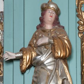 Zdjęcie nr 1: Rzeźba ścięta z tyłu, drążona, przedstawia nierozpoznanego, świętego królewicza. Figura ustawiona frontalnie, w delikatnym kontrapoście z prawą nogą ugiętą w kolanie, z głową uniesioną do góry. Obie ręce wyciągnięte w prawo. Twarz owalna z wyraźnie zaznaczonym podbródkiem, dużym nosem i małymi ustami. Włosy ciemne, długie, zasłaniające uszy i zawinięte dużymi lokami do tyłu. Święty ubrany jest w buty z wysokimi cholewami, srebrzoną suknię sięgającą do kolan z długimi rękawami, oraz złocony płaszcz królewski z gronostajowym podbiciem i pelerynką. Na głowie zamknięta korona. Polichromia naturalistyczna w odsłoniętych partiach ciała, strój i atrybuty złocone.

