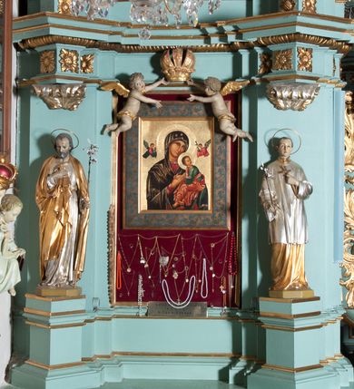 Zdjęcie nr 1: Ołtarz architektoniczny, dwukondygnacyjny, jednoosiowy. Ołtarz drewniany prostopadłościenny z drewnianą mensą i kamiennym portatylem. Dwukondygnacyjne retabulum ustawione na podwójnym cokole, ujęte parą zdwojonych pilastrów wspierających wyłamujące się belkowanie. W polu głównym umieszczony jest obraz Matki Boskiej Nieustającej Pomocy w płytkiej wnęce w kształcie stojącego prostokąta, wyłożonej czerwonym materiałem. Po bokach, na osi podpór, na wysokich cokołach ustawione są rzeźby: po lewej stronie św. Józefa, a po prawej św. Stanisława Kostki. Ponad nimi podwieszone fragmenty fryzu ozdobione rozetami na ściankach bocznych, a od spodu szerokimi, zawiniętymi liśćmi akantu. Druga kondygnacja ustawiona na niskim cokole, ujęta parą zdwojonych pilastrów podtrzymujących przerwane belkowanie oraz wolutowy, odwrócony przyczółek, na którego szczycie usadzona jest para aniołków. W polu środkowym w ramie o kształcie stojącego prostokąta i ściętych narożach obraz św. Rafała z Tobiaszem. Na osi podpór, na niskich cokołach ozdobionych rozetami ustawione są figury aniołów. Ponad nimi podwieszone fragmenty fryzu, zdobione rozetami oraz z podwieszonymi szyszkami. Na szczycie retabulum niski cokolik, flankowany wolutami, zdobiony na przodzie rozetą z zatkniętym u góry krzyżem zakonu Bożogrobowców. Kolorystyka struktury w kolorze jasnej zieleni, ornamentyka i detal architektoniczny złocone oraz srebrzone.