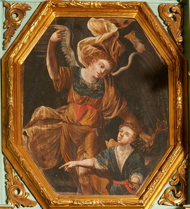 Zdjęcie nr 1: Obraz w kształcie wydłużonego, stojącego ośmioboku z przedstawieniem św. Rafała Archanioła z młodym Tobiaszem. Archanioł ukazany jest frontalnie, do wysokości kolan o esowato wygiętej sylwetce w lewą stronę, prawą rękę z wyprostowanym palcem wskazującym unosi do góry, a w lewej opuszczonej nisko trzyma krucyfiks. Archanioł ma owalną twarz o idealizujących rysach twarzy z pełnymi ustami, prostym nosem i dużymi oczami, okoloną kędzierzawymi i jasnobrązowymi włosami. Ubrany jest w brązową tunikę, przewiązaną czerwoną tasiemką w talii oraz jasnobrązowy płaszcz, zarzucony przez lewe ramię i biegnący z tyłu przez plecy z dwoma końcami rozwianymi w dolnej i górnej części obrazu, ponadto na dekolcie ma założoną górną część napierśnika w kolorze niebieskim, a u pleców rozłożone duże ciemnoszare skrzydła. W prawym dolnym narożu obrazu ukazany jest w półpostaci Tobiasz, zwrócony trzy czwarte w prawo z prawą ręką odwiedzioną w bok i z wyprostowanym palcem wskazującym, w lewej dłoni trzyma przy boku zawieszoną szabelkę. Twarz pełna z dużymi oczami, pełnymi ustami i szerokim na końcu nosem, włosy krótkie i kędzierzawe.Ubrany jest w białą, krótką koszulę oraz niebieski kontusz z krótkimi rękawami, przewiązany czerwonym pasem. Karnacja obu postaci jest bardzo jasna. Tło obrazu ciemne, miejscami widoczne elementy ciemnozielonej roślinności. Rama drewniana, profilowana i zdobiona liśćmi wawrzynu.
