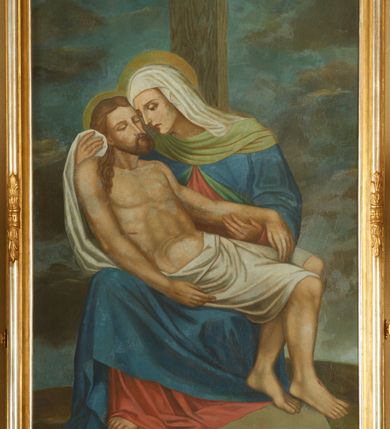 Zdjęcie nr 2: Obraz w kształcie stojącego prostokąta w profilowanej, złocono-srebrzonej ramie, dekorowanej pośrodku boków liśćmi wawrzynu, przewiązanymi opaską. W centrum kompozycji znajduje się Maria trzymająca na kolanach martwe ciało Chrystusa. Maria siedzi na prostopadłościennym, kamiennym podeście, za jej plecami znajduje się pionowa belka krzyża. Matka Boska jest pochylona w prawą stronę z głową skłonioną w stronę twarzy Chrystusa, dłońmi podtrzymuje jego głowę i lewą rękę. Jest ubrana w czerwoną suknię z długimi rękawami, niebieski płaszcz z zieloną podszewką, szeroko wywiniętą na dekolcie oraz biały welon na głowie. Maria ma podłużną twarz z wyraźnie zaznaczonym podbródkiem, długim nosem i dużymi oczami. Chrystus ukazany jest w pozycji półleżącej na kolanach Matki, widoczny z prawego profilu. Twarz Chrystusa jest szczupła, okolona krótką brodą i długimi, ciemnobrązowymi włosami, spływającymi na plecy i prawe ramię, oczy ma zamknięte. Zbawiciel odziany jest w białe płótno, przewiązane przez biodra, którego długi koniec Maria podtrzymuje prawą dłonią. Na stopach, dłoniach i boku Chrystusa są delikatnie zaznaczone ślady Męki, karnacja ciała jest blado-szara. Wokół głów Chrystusa i Marii znajdują się koliste i złote nimby. Tło obrazu jest pochmurne, horyzont obniżony, kolorystyka w tle ciemna, na postaciach Marii i Chrystusa barwy w odcieniu pastelowym.