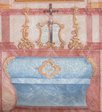 Zdjęcie nr 4: Polichromia ścienna przedstawia ukazany w sposób iluzjonistyczny ołtarz boczny św. Józefa. Mensa sarkofagowa, ozdobiona rocaille’owym kartuszem z napisem: „Dia 22 / July / 1796.”. Nastawa ustawiona na zdwojonym cokole. W górnej partii cokołu trzy rocaille’owe płyciny z modlitwami z kanonu mszy świętej. Na płycinie środkowej: „Gloria Credo in Deo / HOC EST ENIM / CORPUS MEUM”. Na płycinie lewej: „Evange/lium S 90 / IN principca / cruc Verbum, (…)VERBUM / CA(…)FA”. Na płycinie prawej: „Deus (…) / Mc / LAVabo inter / innocentes / manus meas”. Na mensie ołtarzowej na tle kanonu ustawiony jest krucyfiks, a po bokach dwa rokokowe lichtarze. Nastawa ujęta parami pilastrów, ustawionymi przed nimi filarami oraz kolumnami. Kolumny o kręconych trzonach, kapitele fantazyjne. Podpory podtrzymują pełne, przerwane nad polem głównym belkowanie z wolutowymi przyczółkami, na których usadzona jest para aniołków. W polu głównym w ramie w kształcie stojącego prostokąta zamkniętego łukiem wklęsło-wypukłym z uskokami jest namalowany obraz św. Józefa z Dzieciątkiem. Po bokach ołtarza rocaille’owe uszy ze zwisami kwiatowymi. Zwieńczenie w kształcie zbliżonym do stojącego prostokąta o wklęsłych bokach, ujętych spływami wolutowymi, na których w górnej części po bokach znajdują się imposty z usadzonymi na nich dwoma aniołkami. Szczyt zamknięty czterema spiętymi wolutkami, pośrodku krzyż o kształcie krzyża maltańskiego, poniżej podwieszony pas lambrekinu. W polu głównym zwieńczenia w owalnej ramie obraz przedstawiający św. Jana Nepomucena. Zwieńczenie dekorowane zwisami z gałązek różanych. Nastawa marmoryzowana w kolorze jasnoróżowym i jasnoróżowym, trzony kolumn, rama obrazu ze św. Janem Nepomucenem oraz mensa w kolorze jasnoniebieskim, a ornamentyka malowana jest w kolorze złotym. 