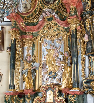 Zdjęcie nr 2: Ołtarz przyścienny, architektoniczny z mensą w formie sarkofagu o wklęsło-wypukłych bokach. W mensie kamienny portatyl. Retabulum jednoosiowe, jednokondygnacyjne ze zwieńczeniem, ustawione na wysokim zdwojonym cokole, zryzalitowanym bo bokach. Nastawa ujęta parą narożnych pilastrów kompozytowych oraz parą kolumn znacznie wysuniętych przed lico ołtarza. Kolumny o kanelowanych trzonach i kompozytowych głowicach podtrzymują faliste belkowanie. Zwieńczenie ujęte po bokach motywami „S” kształtnymi o wolutowo zwiniętych końcach, z których dolne mocno wysunięte do przodu, spoczywają na belkowaniu. Zwieńczenie zamknięte dwoma stykającymi się wolutami. Po bokach retabulum ażurowe uszaki formowane z grzebieni rocaille'owych i motywów „C” kształtnych z rzeźbioną, uskrzydloną główką anielską. 
Pole środkowe w kształcie prostokątnej wnęki z zamknięciem kształtowanym z motywów „C”. We wnęce płaskorzeźba z przedstawieniem Najświętszej Marii Panny Niepokalanie Poczętej ujęta podwójną profilowaną ramą. U dołu, po bokach wnęki dwie konsole z ustawionymi pełnoplastycznymi figurami św. Elżbiety po prawej oraz św. Anny po lewej stronie. Święta Elżbieta trzyma kartę z napisem: „IOANNES / EST / NOMEN / EIUS / Ann(…)”, a święta Anna otwartą księgę zapisaną słowami: „Merito igitur / germen eadem / Anaa divino germo reult / Spiritus pierna liberi libent / Labori qve durionustructa / Vertat am sancti ludaribusmais / Clamorite me cum opta / veram”. Ponad kolumnami, po bokach zwieńczenia dwie figury aniołów, powyżej para uskrzydlonych puttów. W zwieńczeniu owalna wnęka z obrazem przedstawiającym św. Jana Chrzciciela, ujętym podwójną ramą. 
Ołtarz bogato dekorowany. Mensa zdobiona ornamentem rocaille'owym. Pola cokołów zdobione płycinami kształtowanymi z grzebieni rocaille'owych dekorujących też fryz. Trzony kolumn i pilastrów zdobią podwieszane motywy rocaille'owe przeplatane z gałązkami róż, tworzącymi również rozległy, ażurowy kartusz nad polem środkowym. Boki zwieńczenia ujęte ażurowymi liśćmi akantu. Poniżej wnęki ażurowa, ukośna kratka regencyjna. Boki wnęki i szczyt zwieńczenia dekorowane pełnoplastycznymi rocaille'ami. 
Całość struktury ołtarza pokryta malowaną marmoryzacją w odcieniach zieleni i brązu. Detal architektoniczny złocony, pilastry srebrzone.