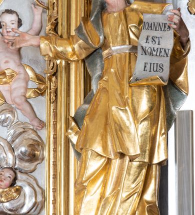 Zdjęcie nr 12: Ołtarz przyścienny, architektoniczny z mensą w formie sarkofagu o wklęsło-wypukłych bokach. W mensie kamienny portatyl. Retabulum jednoosiowe, jednokondygnacyjne ze zwieńczeniem, ustawione na wysokim zdwojonym cokole, zryzalitowanym bo bokach. Nastawa ujęta parą narożnych pilastrów kompozytowych oraz parą kolumn znacznie wysuniętych przed lico ołtarza. Kolumny o kanelowanych trzonach i kompozytowych głowicach podtrzymują faliste belkowanie. Zwieńczenie ujęte po bokach motywami „S” kształtnymi o wolutowo zwiniętych końcach, z których dolne mocno wysunięte do przodu, spoczywają na belkowaniu. Zwieńczenie zamknięte dwoma stykającymi się wolutami. Po bokach retabulum ażurowe uszaki formowane z grzebieni rocaille'owych i motywów „C” kształtnych z rzeźbioną, uskrzydloną główką anielską. 
Pole środkowe w kształcie prostokątnej wnęki z zamknięciem kształtowanym z motywów „C”. We wnęce płaskorzeźba z przedstawieniem Najświętszej Marii Panny Niepokalanie Poczętej ujęta podwójną profilowaną ramą. U dołu, po bokach wnęki dwie konsole z ustawionymi pełnoplastycznymi figurami św. Elżbiety po prawej oraz św. Anny po lewej stronie. Święta Elżbieta trzyma kartę z napisem: „IOANNES / EST / NOMEN / EIUS / Ann(…)”, a święta Anna otwartą księgę zapisaną słowami: „Merito igitur / germen eadem / Anaa divino germo reult / Spiritus pierna liberi libent / Labori qve durionustructa / Vertat am sancti ludaribusmais / Clamorite me cum opta / veram”. Ponad kolumnami, po bokach zwieńczenia dwie figury aniołów, powyżej para uskrzydlonych puttów. W zwieńczeniu owalna wnęka z obrazem przedstawiającym św. Jana Chrzciciela, ujętym podwójną ramą. 
Ołtarz bogato dekorowany. Mensa zdobiona ornamentem rocaille'owym. Pola cokołów zdobione płycinami kształtowanymi z grzebieni rocaille'owych dekorujących też fryz. Trzony kolumn i pilastrów zdobią podwieszane motywy rocaille'owe przeplatane z gałązkami róż, tworzącymi również rozległy, ażurowy kartusz nad polem środkowym. Boki zwieńczenia ujęte ażurowymi liśćmi akantu. Poniżej wnęki ażurowa, ukośna kratka regencyjna. Boki wnęki i szczyt zwieńczenia dekorowane pełnoplastycznymi rocaille'ami. 
Całość struktury ołtarza pokryta malowaną marmoryzacją w odcieniach zieleni i brązu. Detal architektoniczny złocony, pilastry srebrzone.