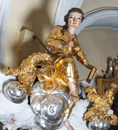 Zdjęcie nr 19: Ołtarz przyścienny, architektoniczny z mensą w formie sarkofagu o wklęsło-wypukłych bokach. W mensie kamienny portatyl. Retabulum jednoosiowe, jednokondygnacyjne ze zwieńczeniem, ustawione na wysokim zdwojonym cokole, zryzalitowanym bo bokach. Nastawa ujęta parą narożnych pilastrów kompozytowych oraz parą kolumn znacznie wysuniętych przed lico ołtarza. Kolumny o kanelowanych trzonach i kompozytowych głowicach podtrzymują faliste belkowanie. Zwieńczenie ujęte po bokach motywami „S” kształtnymi o wolutowo zwiniętych końcach, z których dolne mocno wysunięte do przodu, spoczywają na belkowaniu. Zwieńczenie zamknięte dwoma stykającymi się wolutami. Po bokach retabulum ażurowe uszaki formowane z grzebieni rocaille'owych i motywów „C” kształtnych z rzeźbioną, uskrzydloną główką anielską. 
Pole środkowe w kształcie prostokątnej wnęki z zamknięciem kształtowanym z motywów „C”. We wnęce płaskorzeźba z przedstawieniem Najświętszej Marii Panny Niepokalanie Poczętej ujęta podwójną profilowaną ramą. U dołu, po bokach wnęki dwie konsole z ustawionymi pełnoplastycznymi figurami św. Elżbiety po prawej oraz św. Anny po lewej stronie. Święta Elżbieta trzyma kartę z napisem: „IOANNES / EST / NOMEN / EIUS / Ann(…)”, a święta Anna otwartą księgę zapisaną słowami: „Merito igitur / germen eadem / Anaa divino germo reult / Spiritus pierna liberi libent / Labori qve durionustructa / Vertat am sancti ludaribusmais / Clamorite me cum opta / veram”. Ponad kolumnami, po bokach zwieńczenia dwie figury aniołów, powyżej para uskrzydlonych puttów. W zwieńczeniu owalna wnęka z obrazem przedstawiającym św. Jana Chrzciciela, ujętym podwójną ramą. 
Ołtarz bogato dekorowany. Mensa zdobiona ornamentem rocaille'owym. Pola cokołów zdobione płycinami kształtowanymi z grzebieni rocaille'owych dekorujących też fryz. Trzony kolumn i pilastrów zdobią podwieszane motywy rocaille'owe przeplatane z gałązkami róż, tworzącymi również rozległy, ażurowy kartusz nad polem środkowym. Boki zwieńczenia ujęte ażurowymi liśćmi akantu. Poniżej wnęki ażurowa, ukośna kratka regencyjna. Boki wnęki i szczyt zwieńczenia dekorowane pełnoplastycznymi rocaille'ami. 
Całość struktury ołtarza pokryta malowaną marmoryzacją w odcieniach zieleni i brązu. Detal architektoniczny złocony, pilastry srebrzone.
