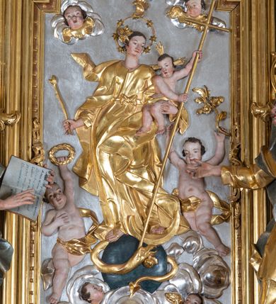 Zdjęcie nr 26: Ołtarz przyścienny, architektoniczny z mensą w formie sarkofagu o wklęsło-wypukłych bokach. W mensie kamienny portatyl. Retabulum jednoosiowe, jednokondygnacyjne ze zwieńczeniem, ustawione na wysokim zdwojonym cokole, zryzalitowanym bo bokach. Nastawa ujęta parą narożnych pilastrów kompozytowych oraz parą kolumn znacznie wysuniętych przed lico ołtarza. Kolumny o kanelowanych trzonach i kompozytowych głowicach podtrzymują faliste belkowanie. Zwieńczenie ujęte po bokach motywami „S” kształtnymi o wolutowo zwiniętych końcach, z których dolne mocno wysunięte do przodu, spoczywają na belkowaniu. Zwieńczenie zamknięte dwoma stykającymi się wolutami. Po bokach retabulum ażurowe uszaki formowane z grzebieni rocaille'owych i motywów „C” kształtnych z rzeźbioną, uskrzydloną główką anielską. 
Pole środkowe w kształcie prostokątnej wnęki z zamknięciem kształtowanym z motywów „C”. We wnęce płaskorzeźba z przedstawieniem Najświętszej Marii Panny Niepokalanie Poczętej ujęta podwójną profilowaną ramą. U dołu, po bokach wnęki dwie konsole z ustawionymi pełnoplastycznymi figurami św. Elżbiety po prawej oraz św. Anny po lewej stronie. Święta Elżbieta trzyma kartę z napisem: „IOANNES / EST / NOMEN / EIUS / Ann(…)”, a święta Anna otwartą księgę zapisaną słowami: „Merito igitur / germen eadem / Anaa divino germo reult / Spiritus pierna liberi libent / Labori qve durionustructa / Vertat am sancti ludaribusmais / Clamorite me cum opta / veram”. Ponad kolumnami, po bokach zwieńczenia dwie figury aniołów, powyżej para uskrzydlonych puttów. W zwieńczeniu owalna wnęka z obrazem przedstawiającym św. Jana Chrzciciela, ujętym podwójną ramą. 
Ołtarz bogato dekorowany. Mensa zdobiona ornamentem rocaille'owym. Pola cokołów zdobione płycinami kształtowanymi z grzebieni rocaille'owych dekorujących też fryz. Trzony kolumn i pilastrów zdobią podwieszane motywy rocaille'owe przeplatane z gałązkami róż, tworzącymi również rozległy, ażurowy kartusz nad polem środkowym. Boki zwieńczenia ujęte ażurowymi liśćmi akantu. Poniżej wnęki ażurowa, ukośna kratka regencyjna. Boki wnęki i szczyt zwieńczenia dekorowane pełnoplastycznymi rocaille'ami. 
Całość struktury ołtarza pokryta malowaną marmoryzacją w odcieniach zieleni i brązu. Detal architektoniczny złocony, pilastry srebrzone.