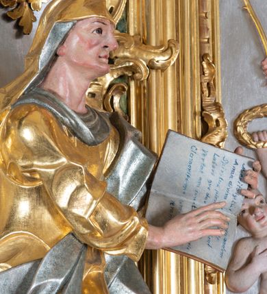 Zdjęcie nr 11: Ołtarz przyścienny, architektoniczny z mensą w formie sarkofagu o wklęsło-wypukłych bokach. W mensie kamienny portatyl. Retabulum jednoosiowe, jednokondygnacyjne ze zwieńczeniem, ustawione na wysokim zdwojonym cokole, zryzalitowanym bo bokach. Nastawa ujęta parą narożnych pilastrów kompozytowych oraz parą kolumn znacznie wysuniętych przed lico ołtarza. Kolumny o kanelowanych trzonach i kompozytowych głowicach podtrzymują faliste belkowanie. Zwieńczenie ujęte po bokach motywami „S” kształtnymi o wolutowo zwiniętych końcach, z których dolne mocno wysunięte do przodu, spoczywają na belkowaniu. Zwieńczenie zamknięte dwoma stykającymi się wolutami. Po bokach retabulum ażurowe uszaki formowane z grzebieni rocaille'owych i motywów „C” kształtnych z rzeźbioną, uskrzydloną główką anielską. 
Pole środkowe w kształcie prostokątnej wnęki z zamknięciem kształtowanym z motywów „C”. We wnęce płaskorzeźba z przedstawieniem Najświętszej Marii Panny Niepokalanie Poczętej ujęta podwójną profilowaną ramą. U dołu, po bokach wnęki dwie konsole z ustawionymi pełnoplastycznymi figurami św. Elżbiety po prawej oraz św. Anny po lewej stronie. Święta Elżbieta trzyma kartę z napisem: „IOANNES / EST / NOMEN / EIUS / Ann(…)”, a święta Anna otwartą księgę zapisaną słowami: „Merito igitur / germen eadem / Anaa divino germo reult / Spiritus pierna liberi libent / Labori qve durionustructa / Vertat am sancti ludaribusmais / Clamorite me cum opta / veram”. Ponad kolumnami, po bokach zwieńczenia dwie figury aniołów, powyżej para uskrzydlonych puttów. W zwieńczeniu owalna wnęka z obrazem przedstawiającym św. Jana Chrzciciela, ujętym podwójną ramą. 
Ołtarz bogato dekorowany. Mensa zdobiona ornamentem rocaille'owym. Pola cokołów zdobione płycinami kształtowanymi z grzebieni rocaille'owych dekorujących też fryz. Trzony kolumn i pilastrów zdobią podwieszane motywy rocaille'owe przeplatane z gałązkami róż, tworzącymi również rozległy, ażurowy kartusz nad polem środkowym. Boki zwieńczenia ujęte ażurowymi liśćmi akantu. Poniżej wnęki ażurowa, ukośna kratka regencyjna. Boki wnęki i szczyt zwieńczenia dekorowane pełnoplastycznymi rocaille'ami. 
Całość struktury ołtarza pokryta malowaną marmoryzacją w odcieniach zieleni i brązu. Detal architektoniczny złocony, pilastry srebrzone.