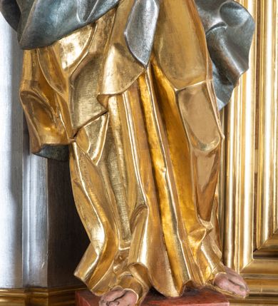 Zdjęcie nr 18: Ołtarz przyścienny, architektoniczny z mensą w formie sarkofagu o wklęsło-wypukłych bokach. W mensie kamienny portatyl. Retabulum jednoosiowe, jednokondygnacyjne ze zwieńczeniem, ustawione na wysokim zdwojonym cokole, zryzalitowanym bo bokach. Nastawa ujęta parą narożnych pilastrów kompozytowych oraz parą kolumn znacznie wysuniętych przed lico ołtarza. Kolumny o kanelowanych trzonach i kompozytowych głowicach podtrzymują faliste belkowanie. Zwieńczenie ujęte po bokach motywami „S” kształtnymi o wolutowo zwiniętych końcach, z których dolne mocno wysunięte do przodu, spoczywają na belkowaniu. Zwieńczenie zamknięte dwoma stykającymi się wolutami. Po bokach retabulum ażurowe uszaki formowane z grzebieni rocaille&#039;owych i motywów „C” kształtnych z rzeźbioną, uskrzydloną główką anielską. 
Pole środkowe w kształcie prostokątnej wnęki z zamknięciem kształtowanym z motywów „C”. We wnęce płaskorzeźba z przedstawieniem Najświętszej Marii Panny Niepokalanie Poczętej ujęta podwójną profilowaną ramą. U dołu, po bokach wnęki dwie konsole z ustawionymi pełnoplastycznymi figurami św. Elżbiety po prawej oraz św. Anny po lewej stronie. Święta Elżbieta trzyma kartę z napisem: „IOANNES / EST / NOMEN / EIUS / Ann(…)”, a święta Anna otwartą księgę zapisaną słowami: „Merito igitur / germen eadem / Anaa divino germo reult / Spiritus pierna liberi libent / Labori qve durionustructa / Vertat am sancti ludaribusmais / Clamorite me cum opta / veram”. Ponad kolumnami, po bokach zwieńczenia dwie figury aniołów, powyżej para uskrzydlonych puttów. W zwieńczeniu owalna wnęka z obrazem przedstawiającym św. Jana Chrzciciela, ujętym podwójną ramą. 
Ołtarz bogato dekorowany. Mensa zdobiona ornamentem rocaille&#039;owym. Pola cokołów zdobione płycinami kształtowanymi z grzebieni rocaille&#039;owych dekorujących też fryz. Trzony kolumn i pilastrów zdobią podwieszane motywy rocaille&#039;owe przeplatane z gałązkami róż, tworzącymi również rozległy, ażurowy kartusz nad polem środkowym. Boki zwieńczenia ujęte ażurowymi liśćmi akantu. Poniżej wnęki ażurowa, ukośna kratka regencyjna. Boki wnęki i szczyt zwieńczenia dekorowane pełnoplastycznymi rocaille&#039;ami. 
Całość struktury ołtarza pokryta malowaną marmoryzacją w odcieniach zieleni i brązu. Detal architektoniczny złocony, pilastry srebrzone.